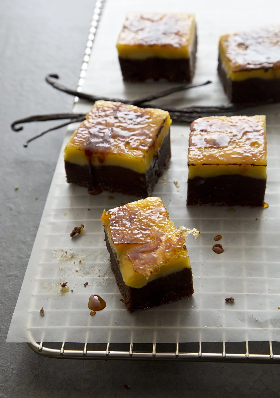Creme brulee brownies on cooling rack, with  golden caramel crust and vanilla bean