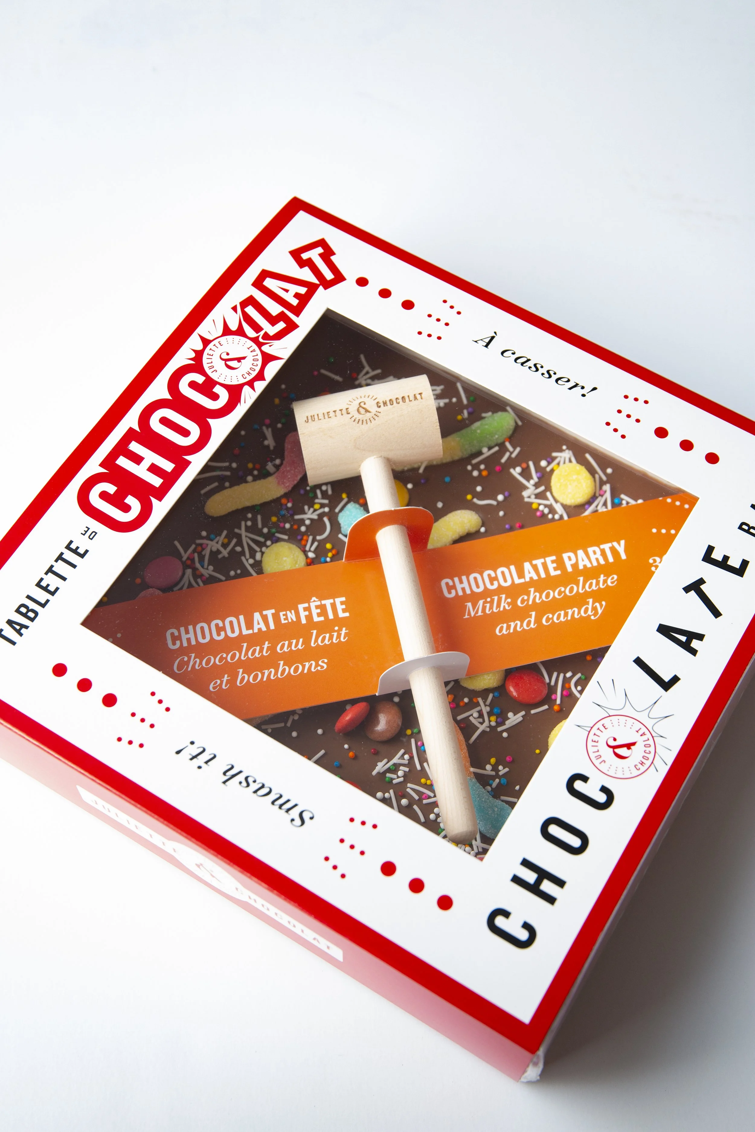 Large square chocolate bar with candies in the chocolate, in a white and red sliding box, by Juliette & Chocolat. 