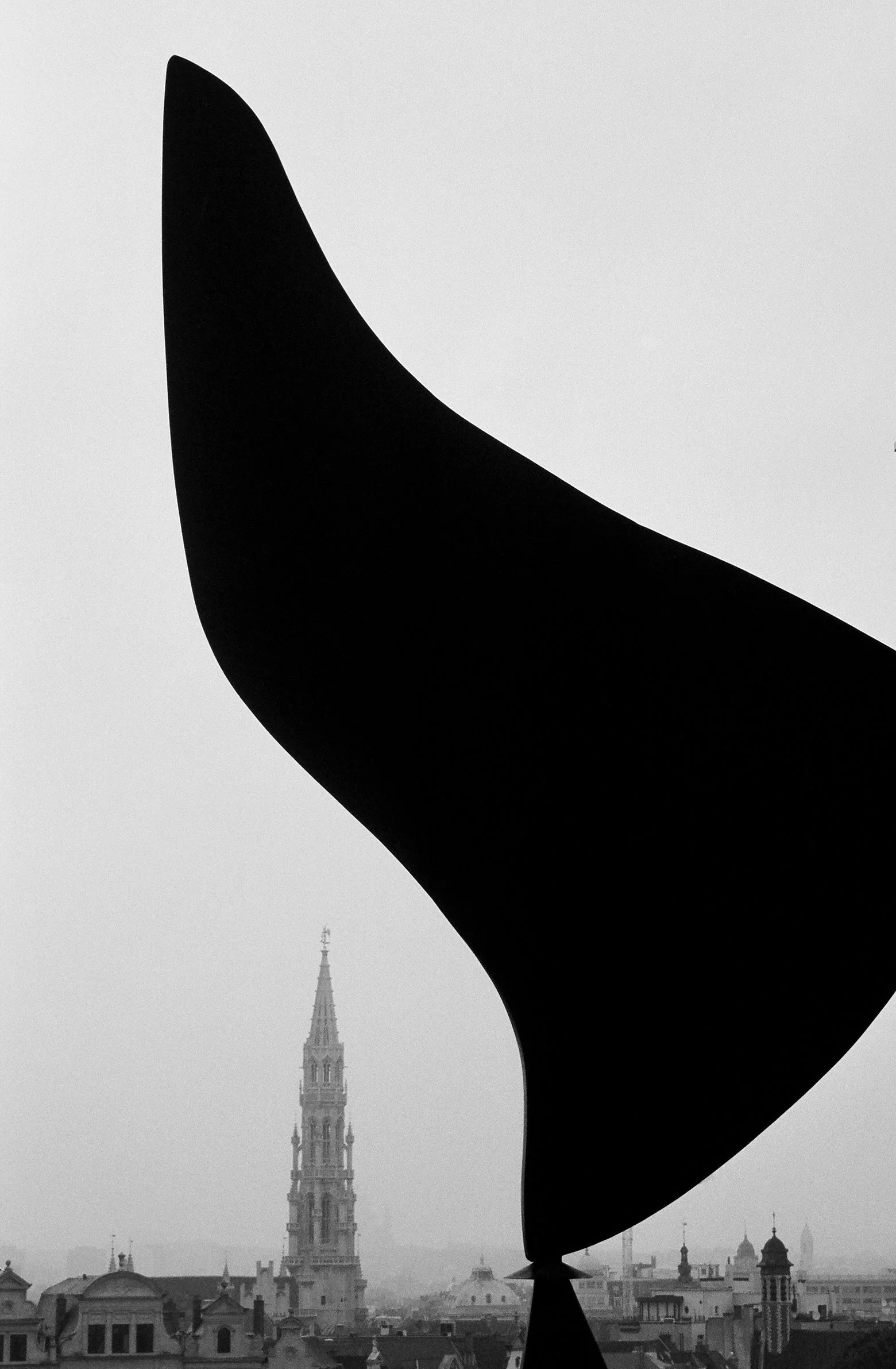Brussels cityscape in black and white, showing City Hall in the distance and a modern sculpture in the foreground, striking composition black and whote photo