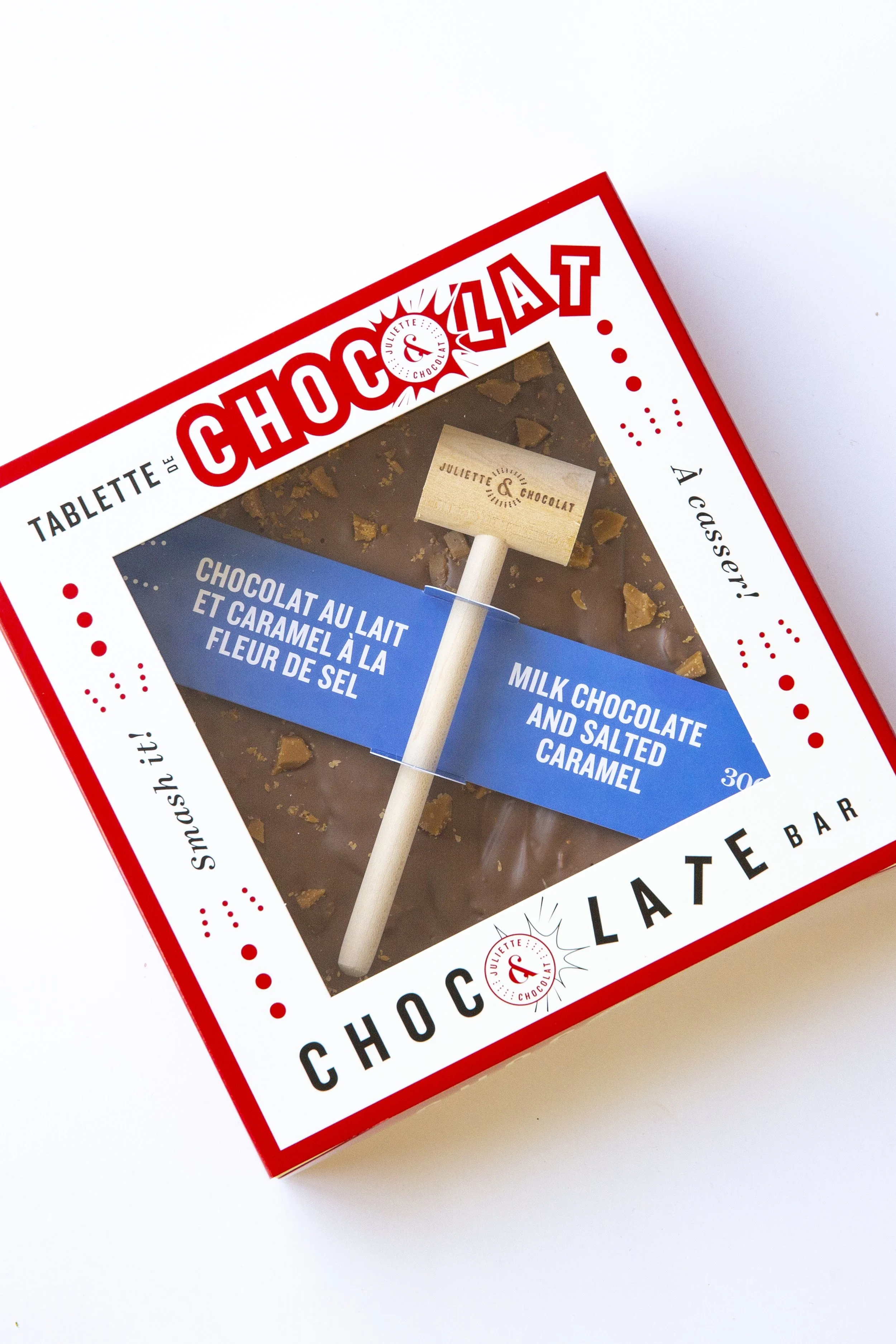 Milk chocolate bar in square box, with small hammer to break the chocolate before eating. 