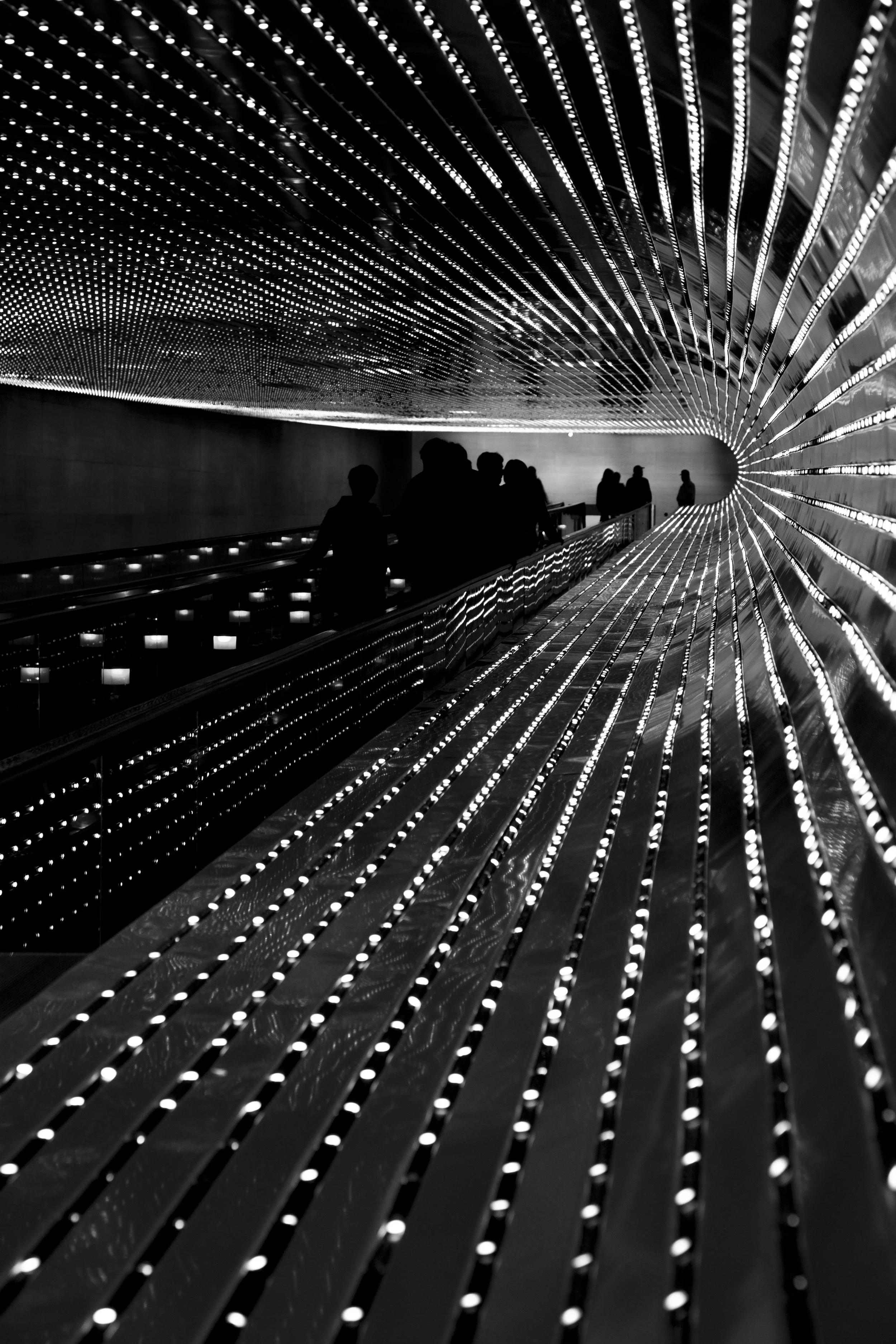Undreground passage at the National Gallery in Washington DC, dramatic lighting with thousands of leds and silhouettes in the distance. 