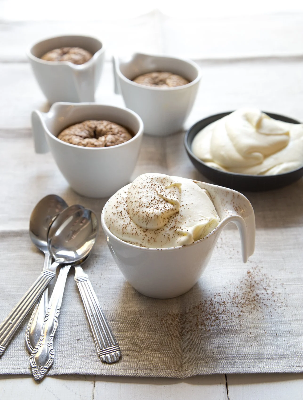 Cappuccino brownies baked in cups, with mascarpone cream and decorated with chocolate shavings.