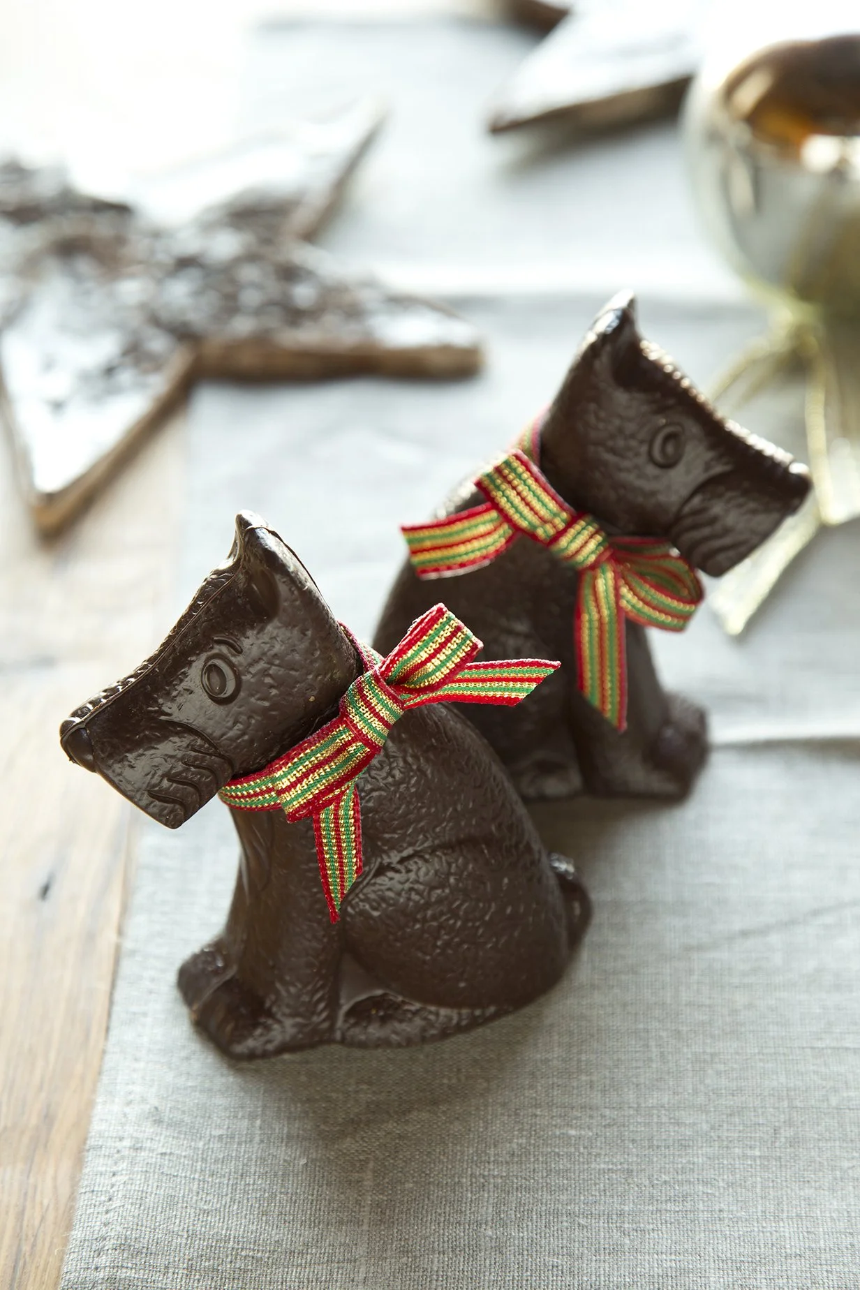 Chocolate confections in the shape of cute dogs with ribbons, dark chocolate Christmas creation
