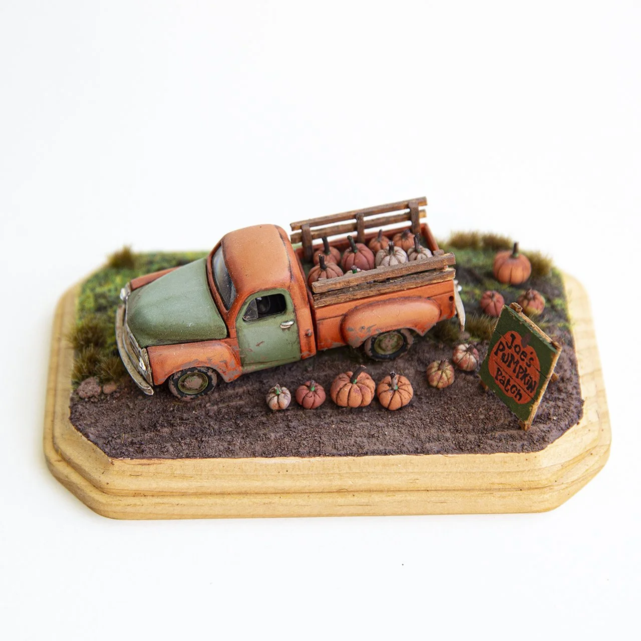 Miniature truck with pumpkin haul, green and orange scale model on custom base. 