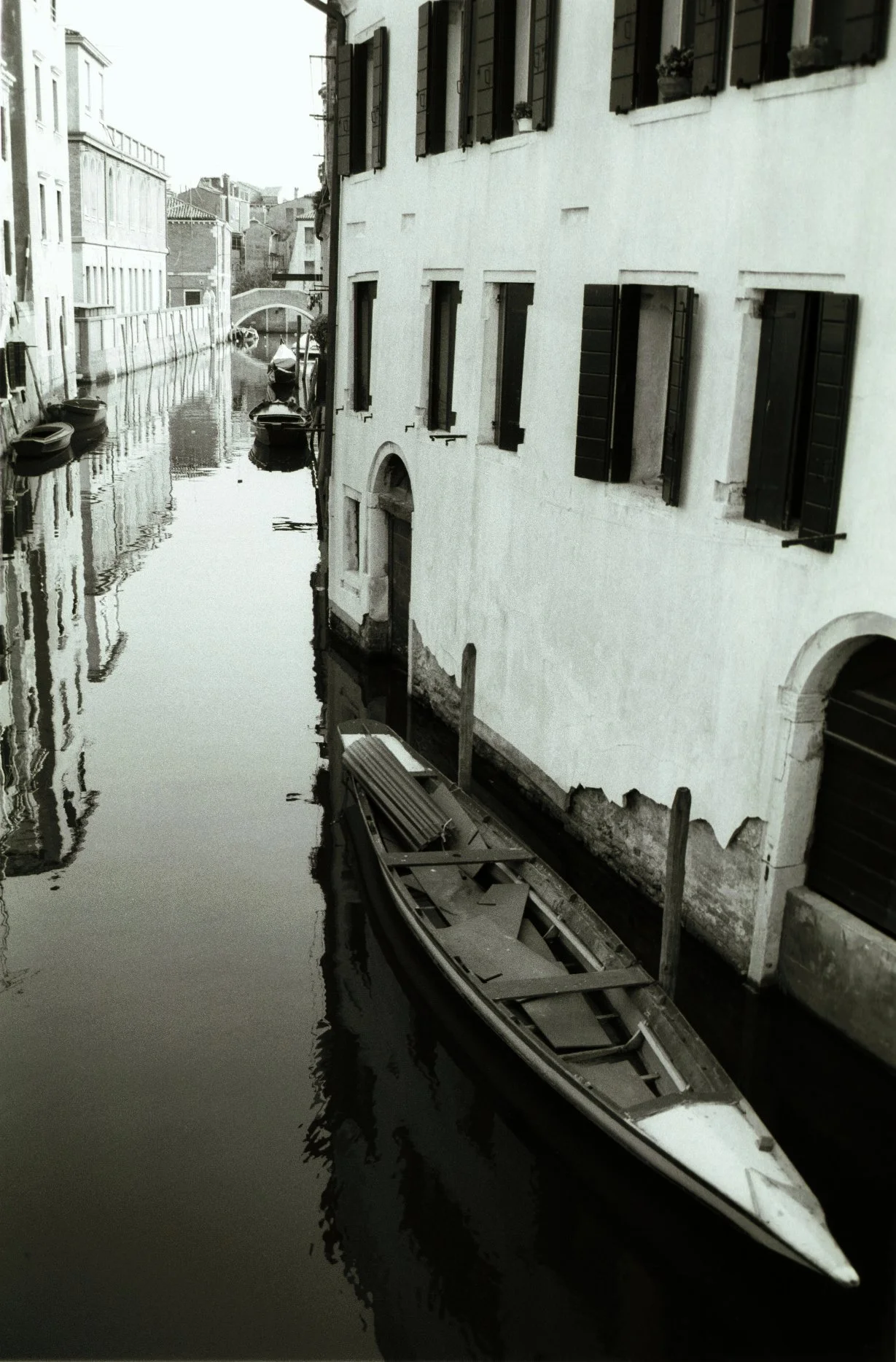 Venice canal and gondola, moody black and white art photograph by Lionel May