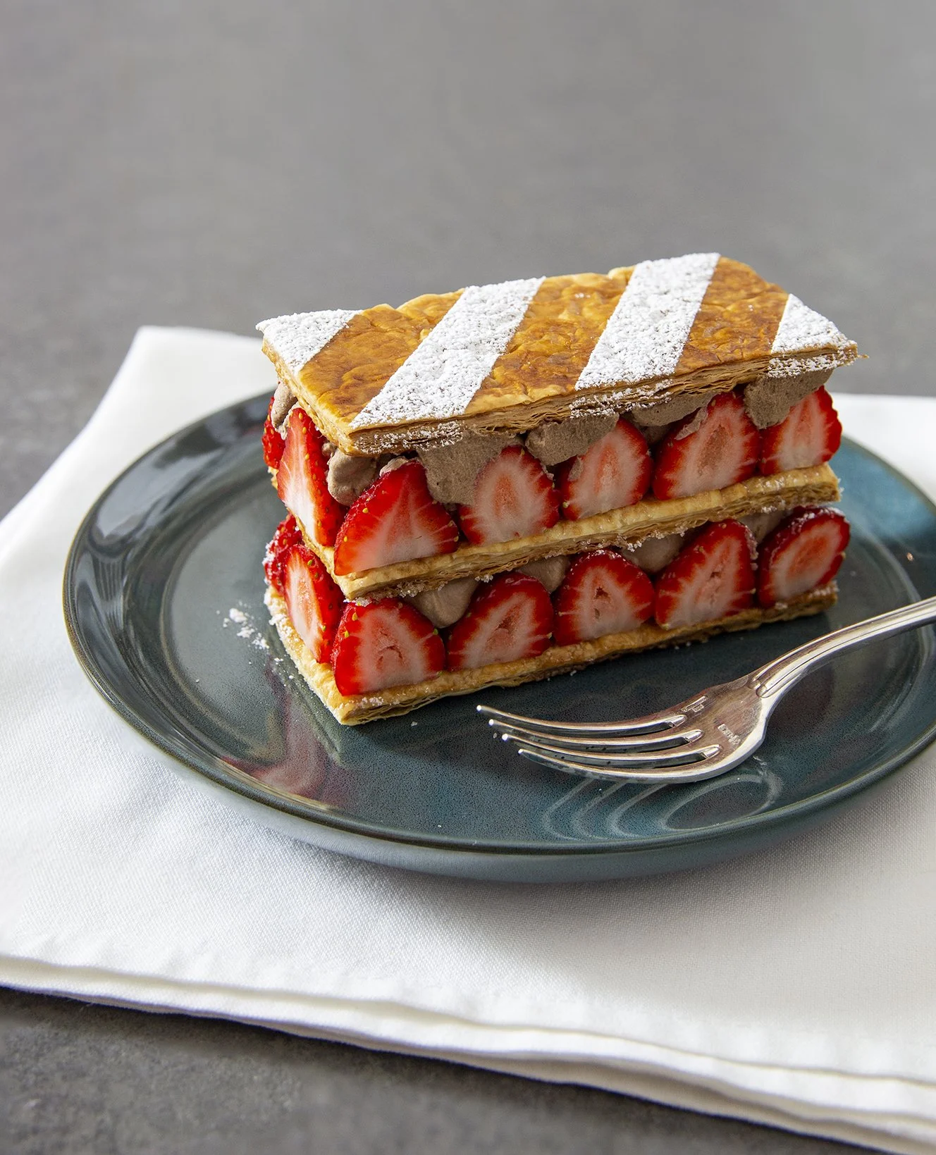 Raspberry and chocolate french mille-feuille pastry on blue serving plate