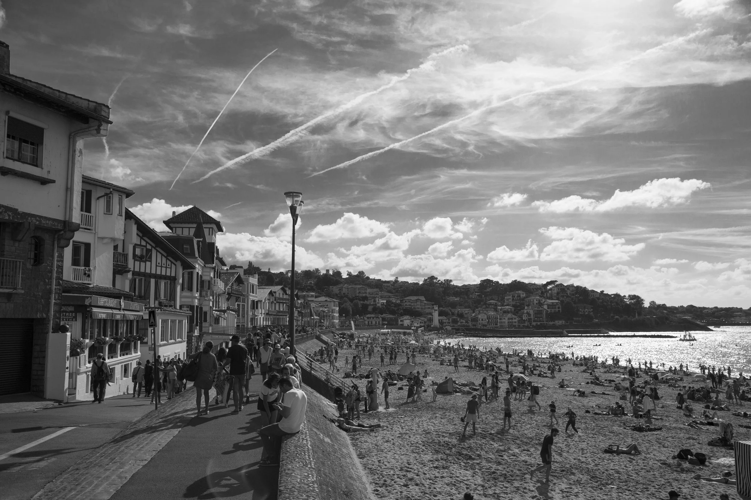 Wide shot of the beach in St-Jean de Luz, France, on a sunny summer day, black and white travel photography by Lionel May