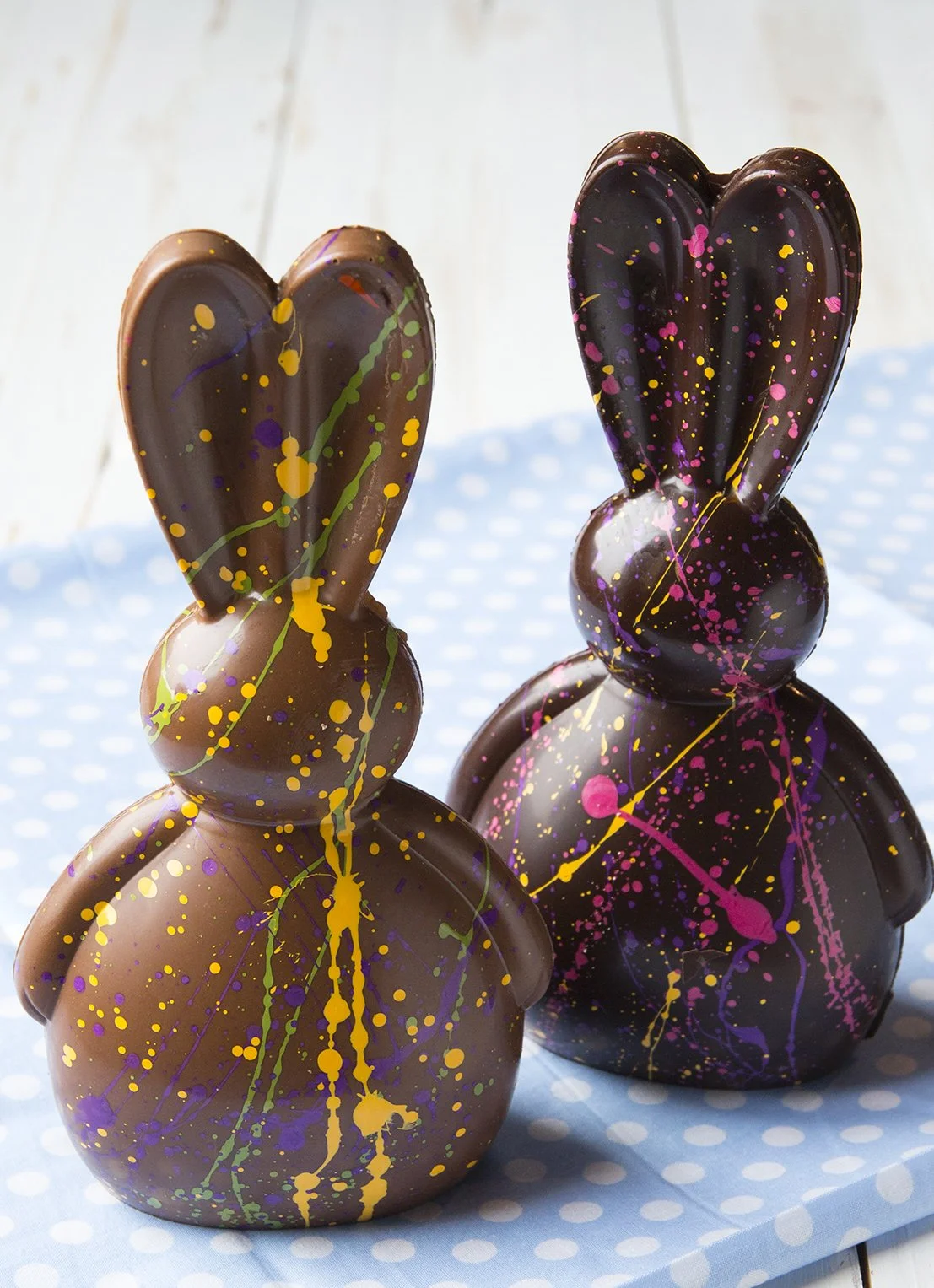 Milk chocolate and dark chocolate bunnies decorated with colorful splashes of white chocolate
