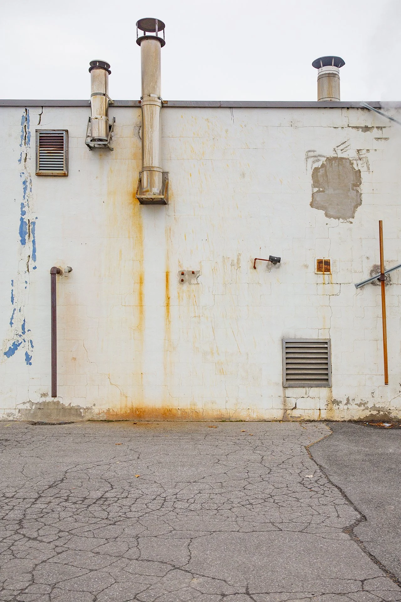 Suburban symmetry, fine art photo, rusted wall and concrete floor, strange beauty in everyday life. 
