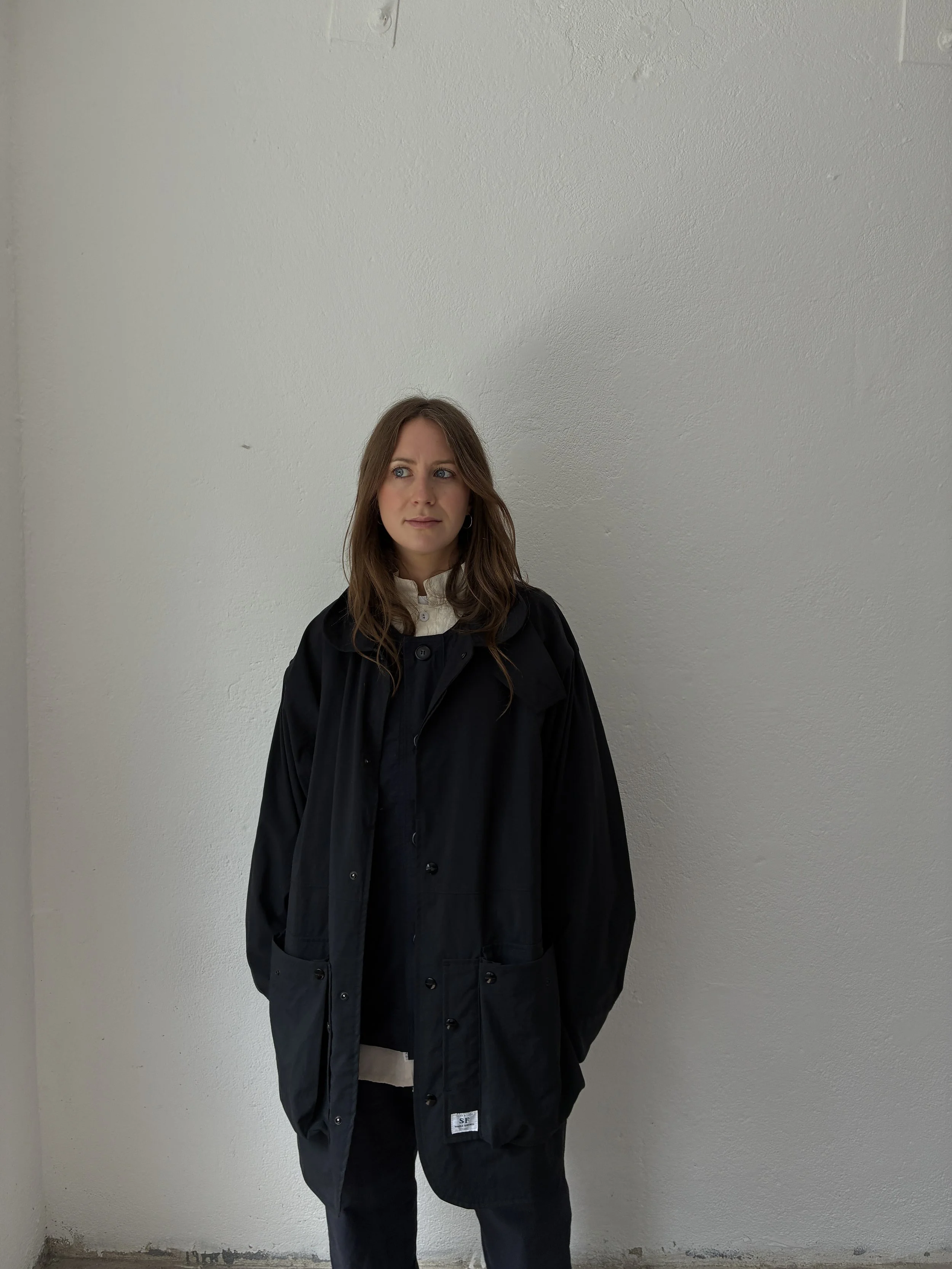 Woman inside wearing Black Sassafras Cultivator Coat