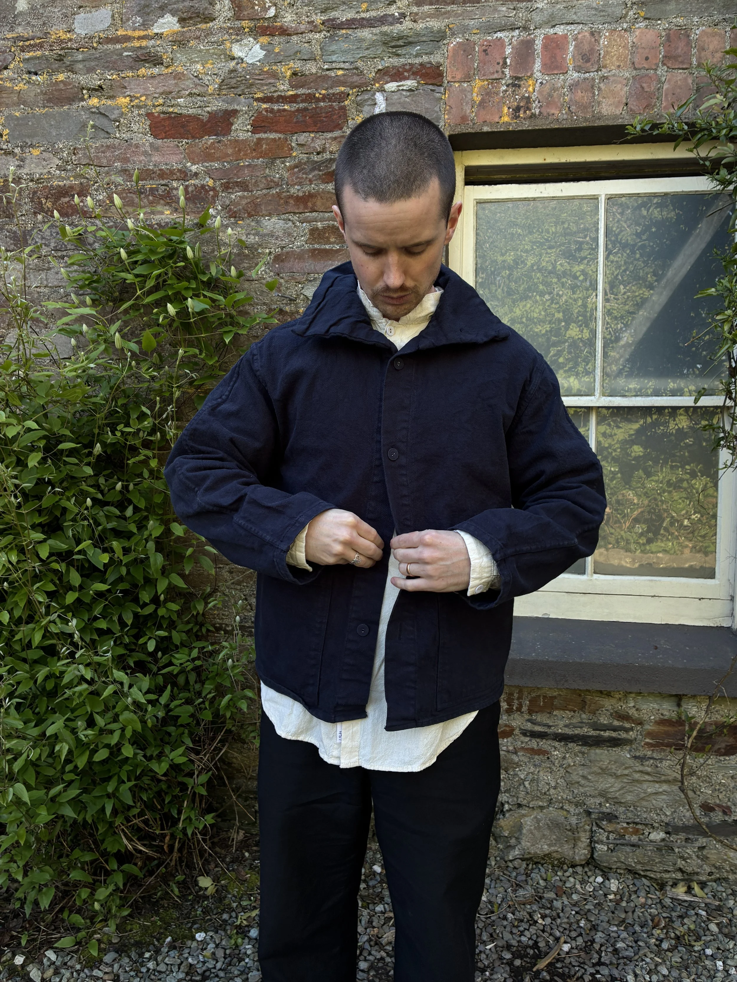 Man buttoning up Tender Hadal Blue 931 Scout Jacket