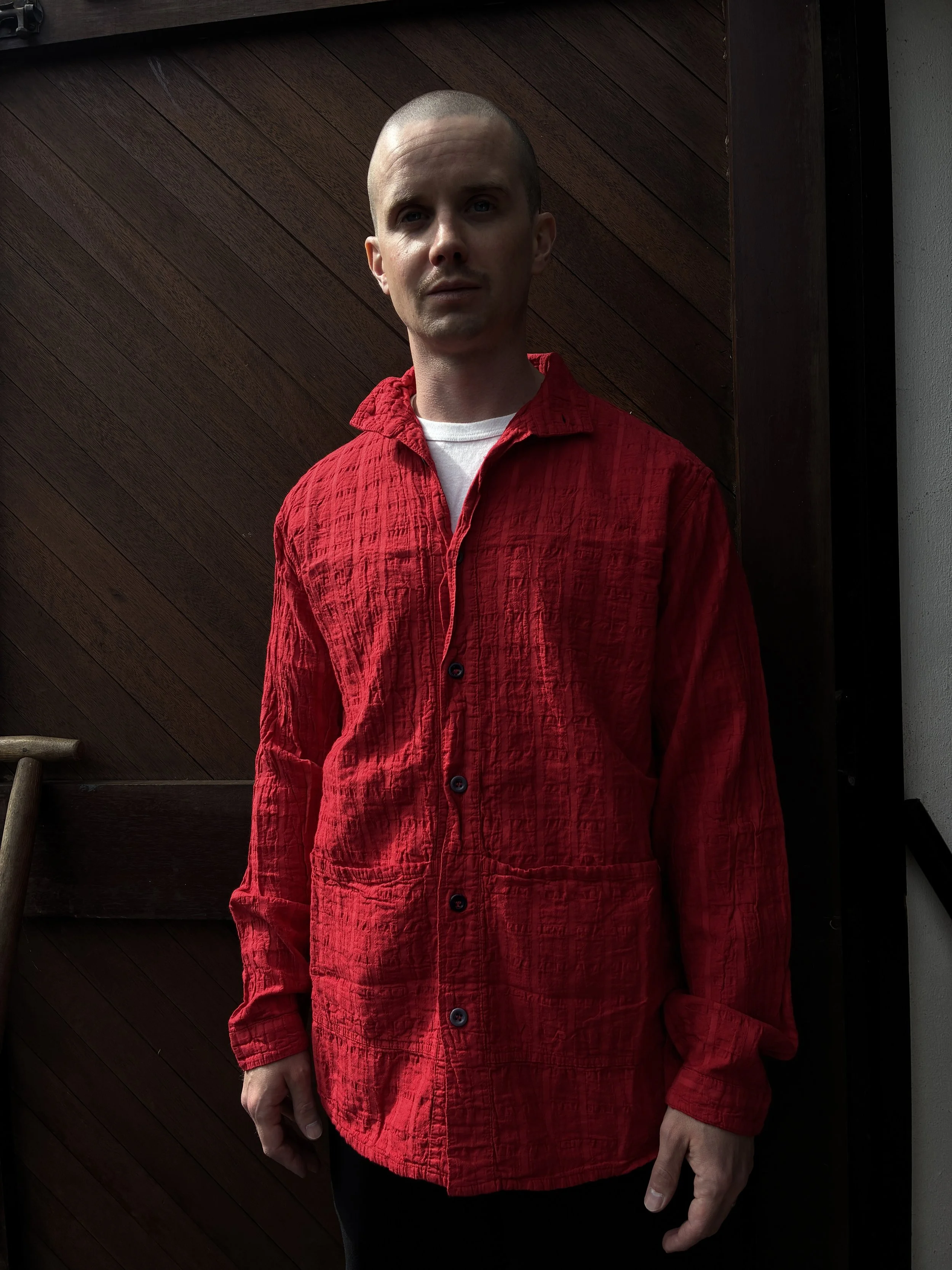 Man in front of wooden door wearing Red Tender Co. 468 Flipped Collar Shirt