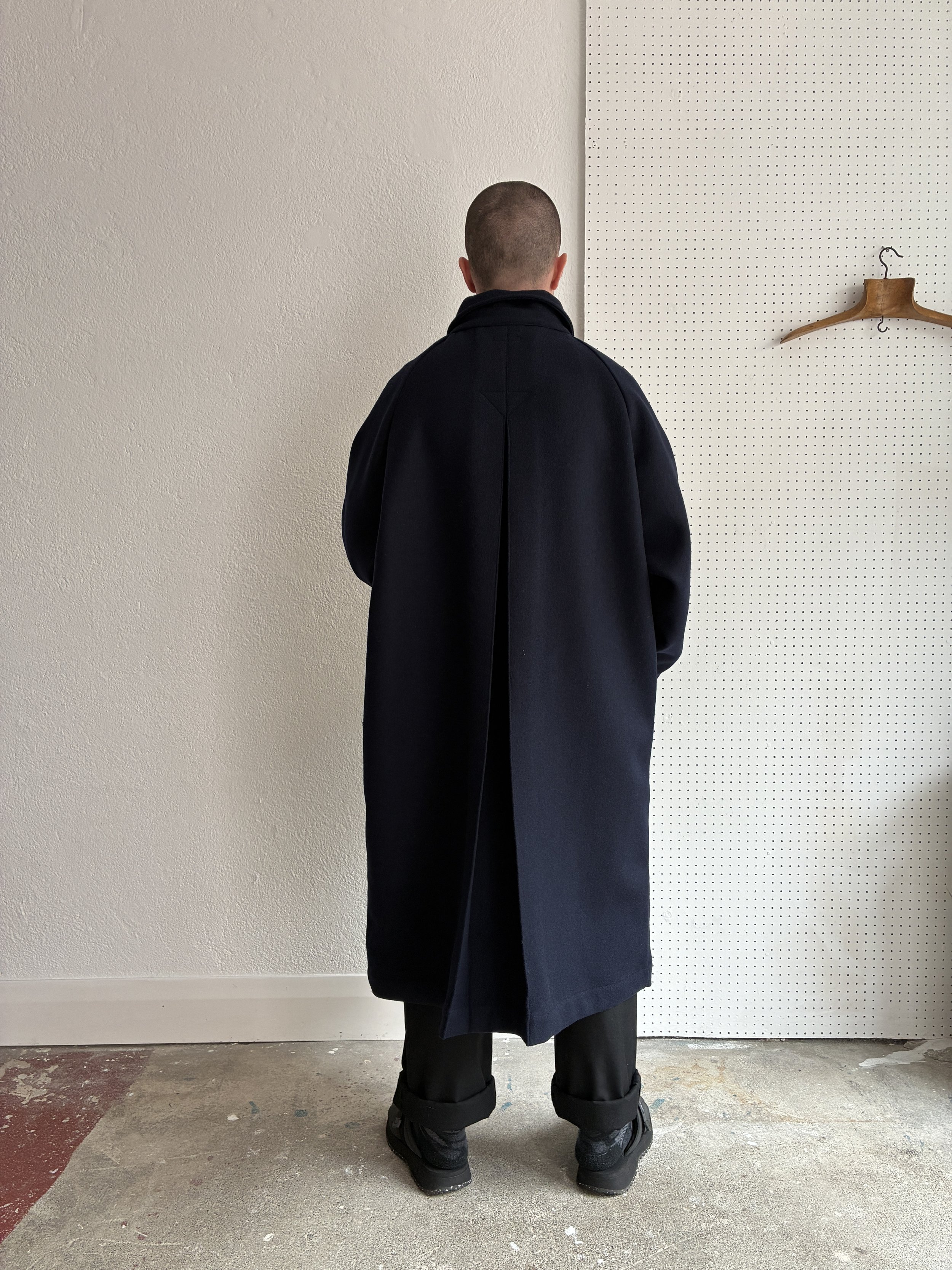 Model wears Frank Leder Navy Wool Duster Coat, back profile view