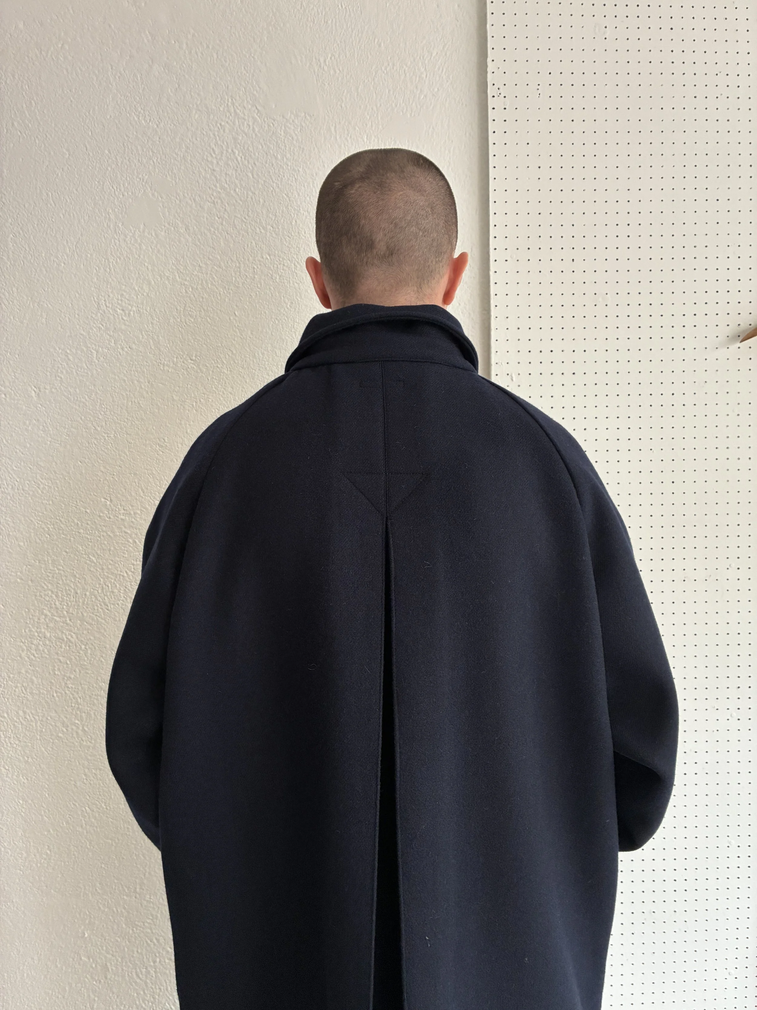 Model wears Frank Leder Navy Wool Duster Coat, back closeup view
