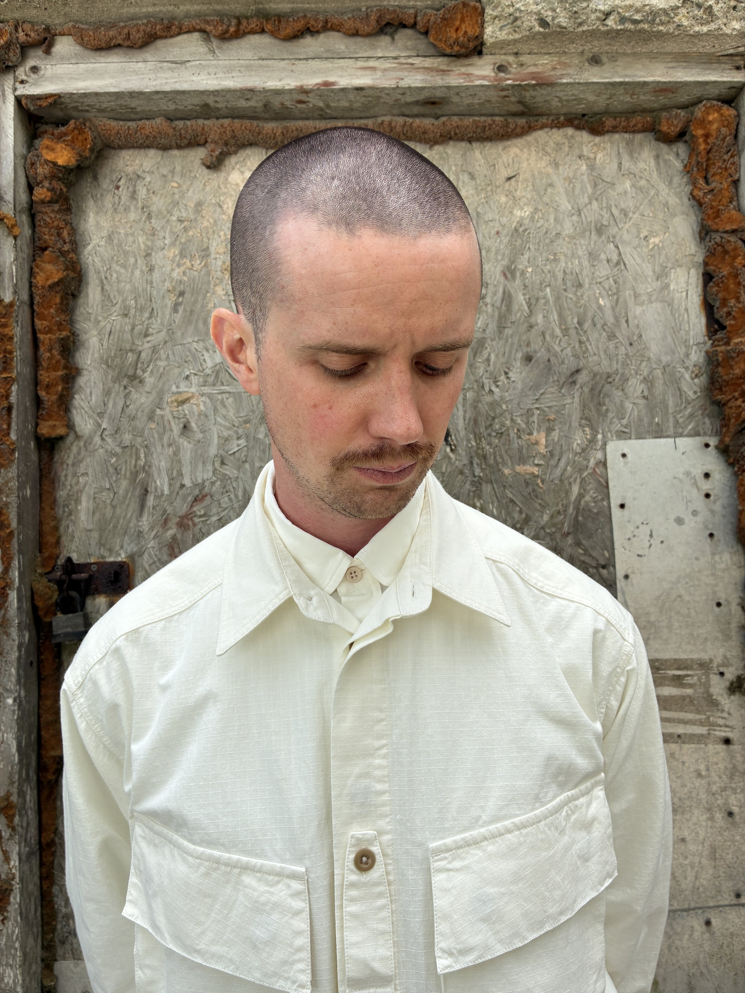 Closeup of Man in front of wall wearing Off-White Ecru 1st PAT-RN Sumatra Overshirt