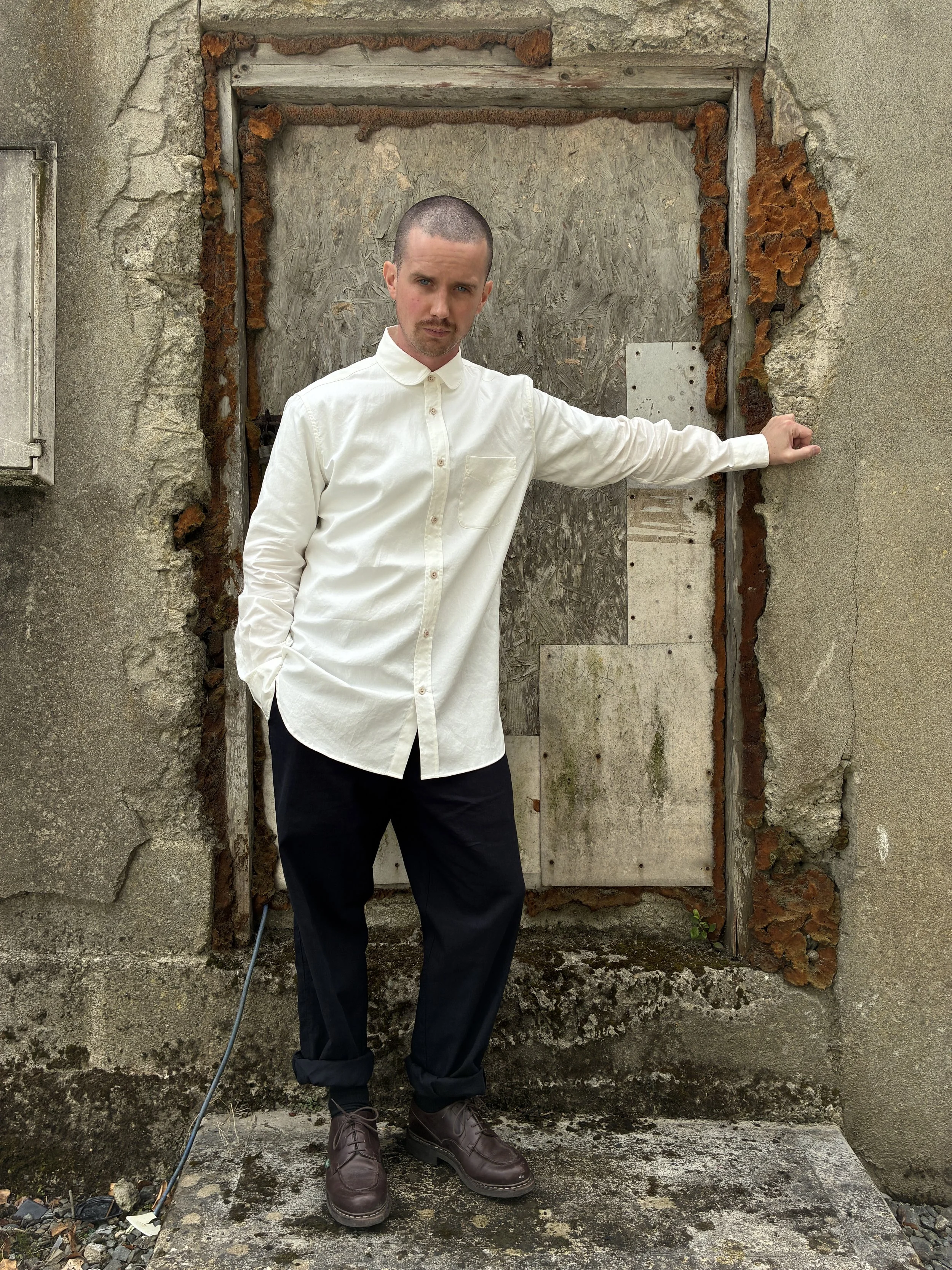 Man leaning against wall wearing White 1st PAT-RN Boston Shirt