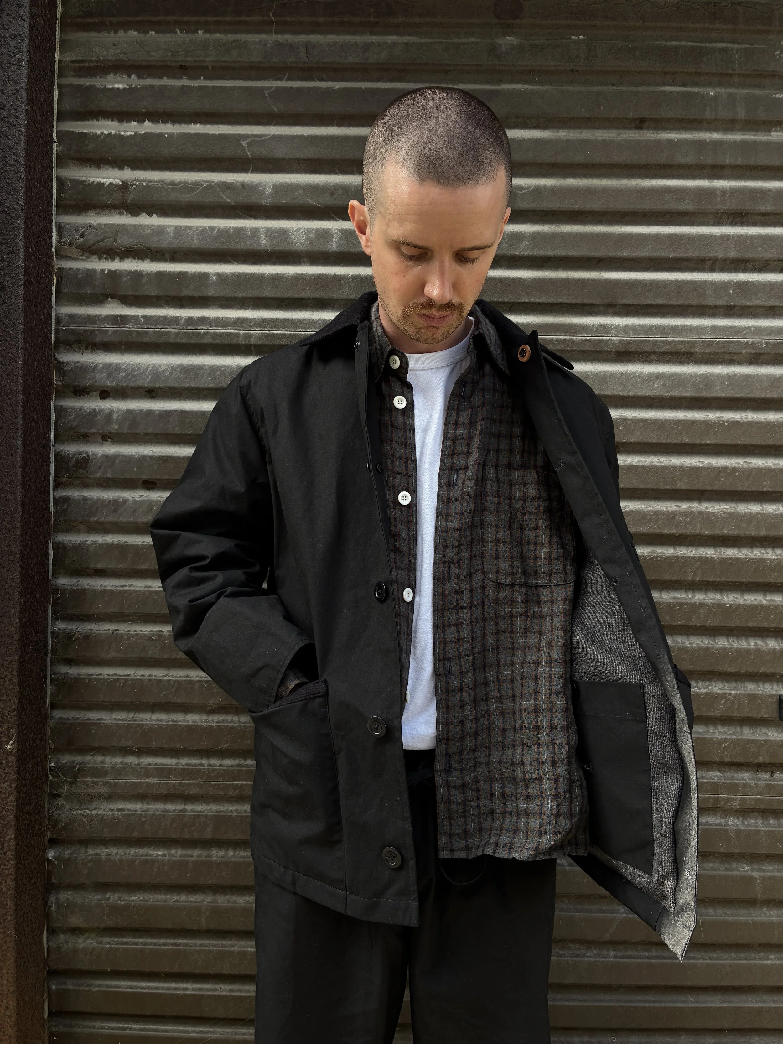 Man wearing Black Conkers Blanket Jacket in front of shutters