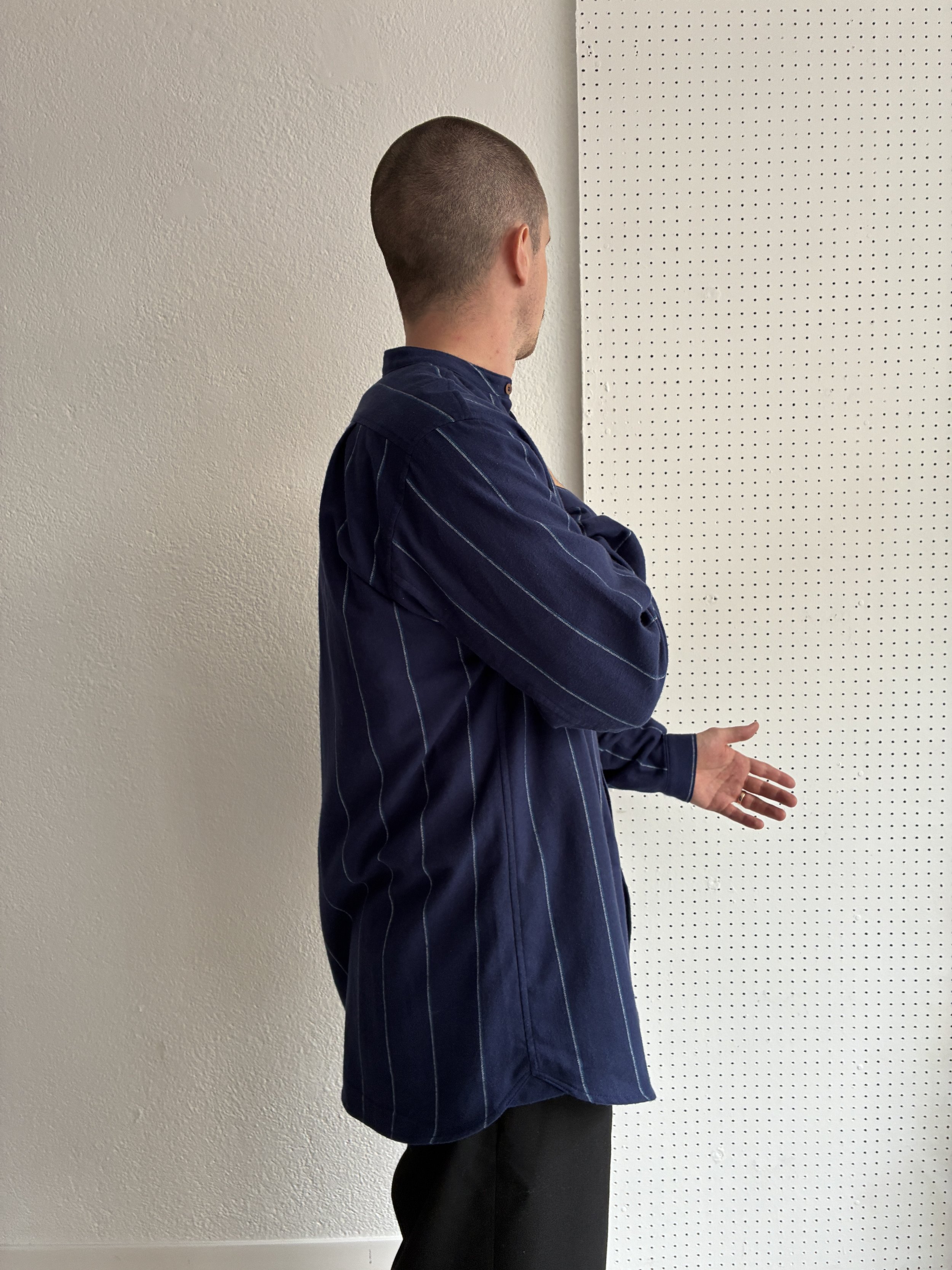 Model wears a Frank Leder navy striped shirt, side profile view.