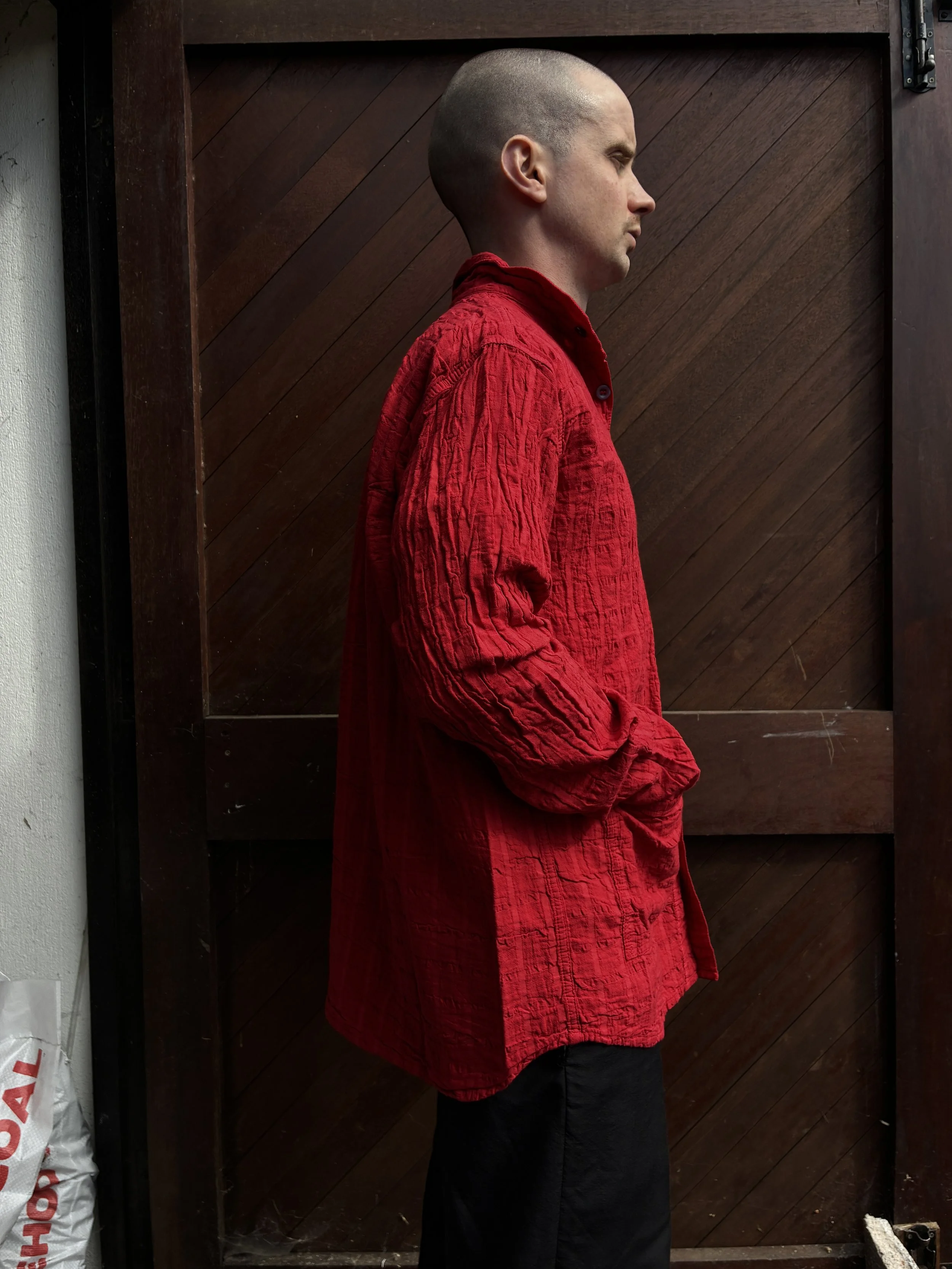 Side of Man in front of wooden door wearing Red Tender Co. 468 Flipped Collar Shirt