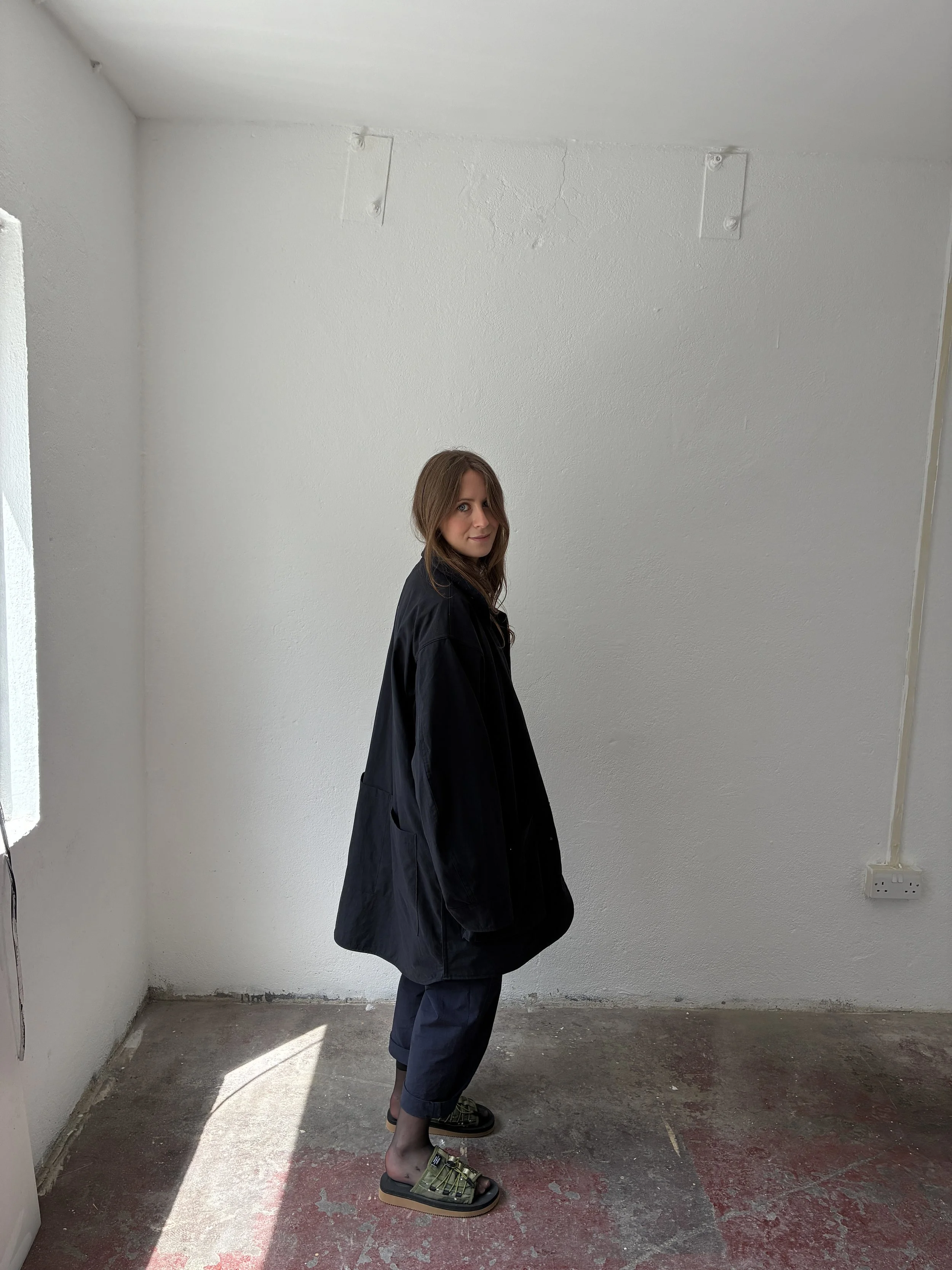 Side profile of woman wearing Black Sassafras Cultivator Coat