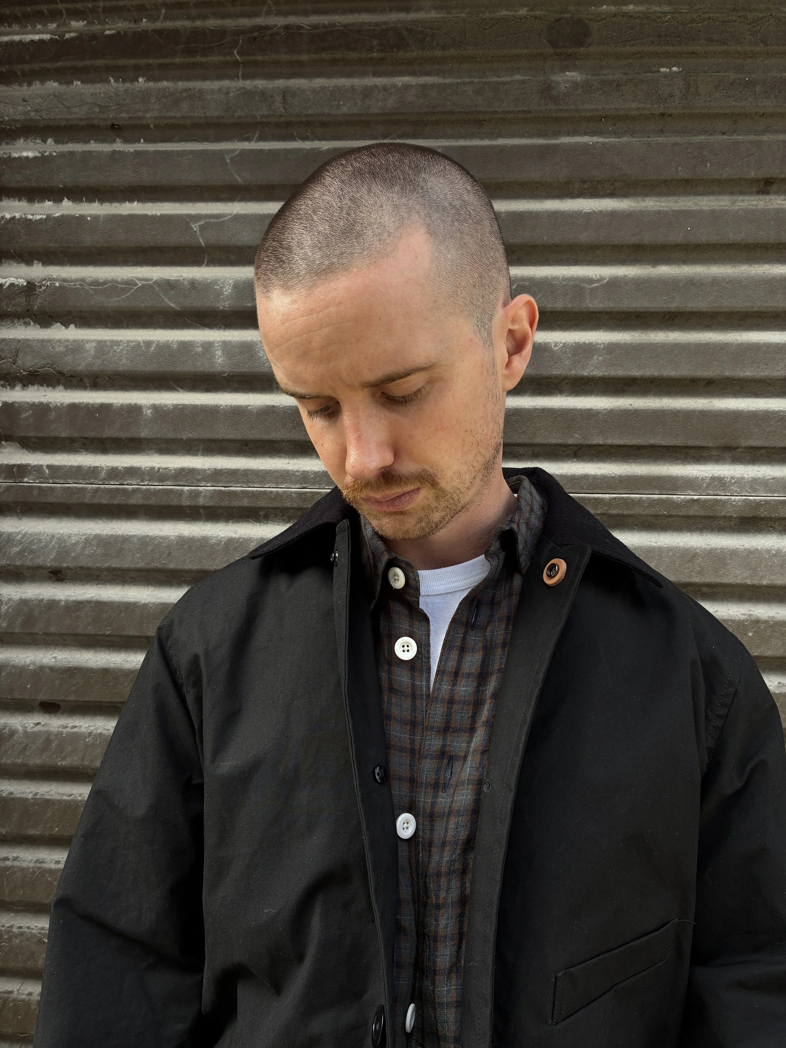 Man wearing Black Conkers Blanket Jacket in front of shutters