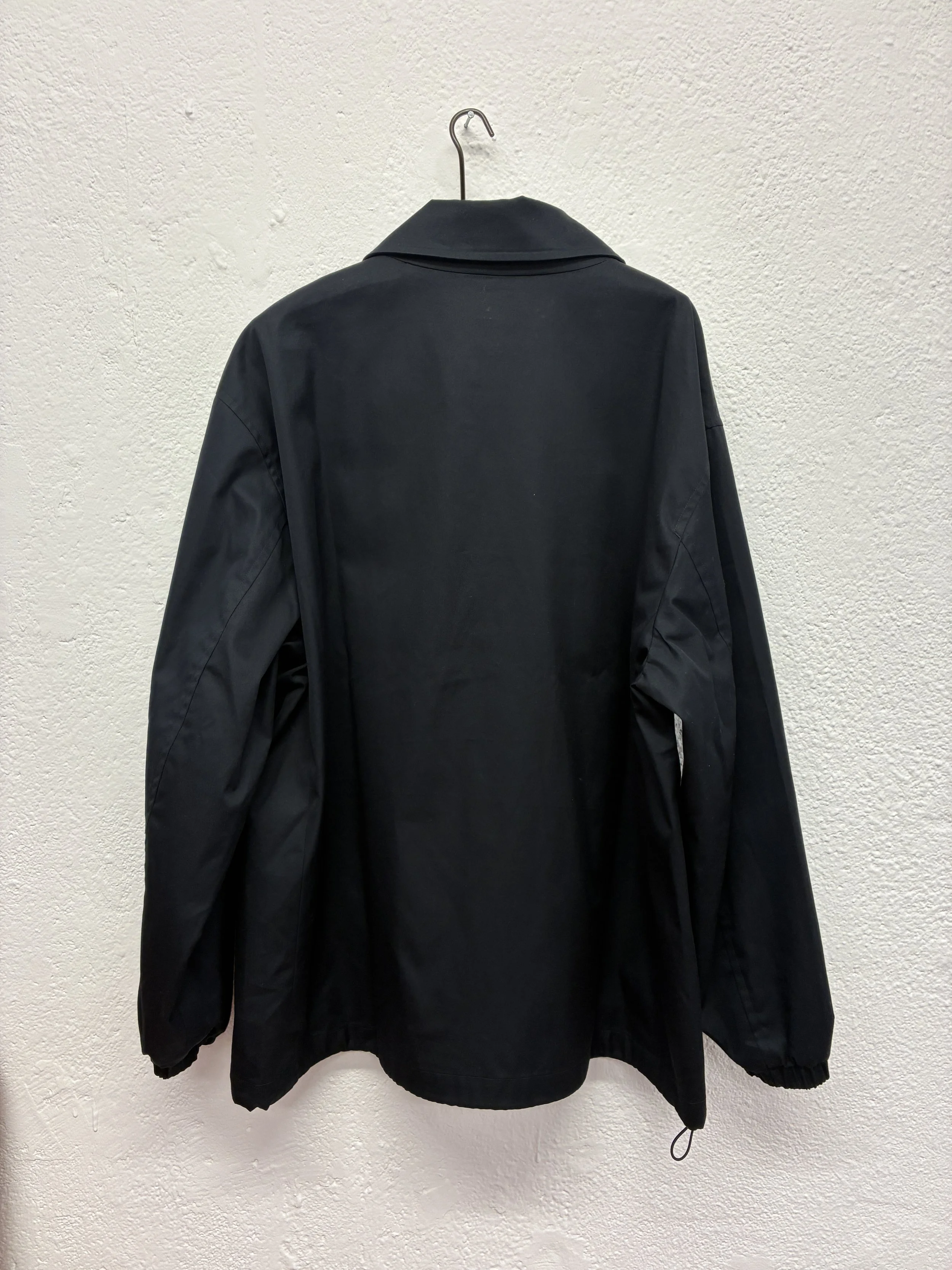Back of Navy De Dam Foundation Cotton Gabardine Jacket on hanger