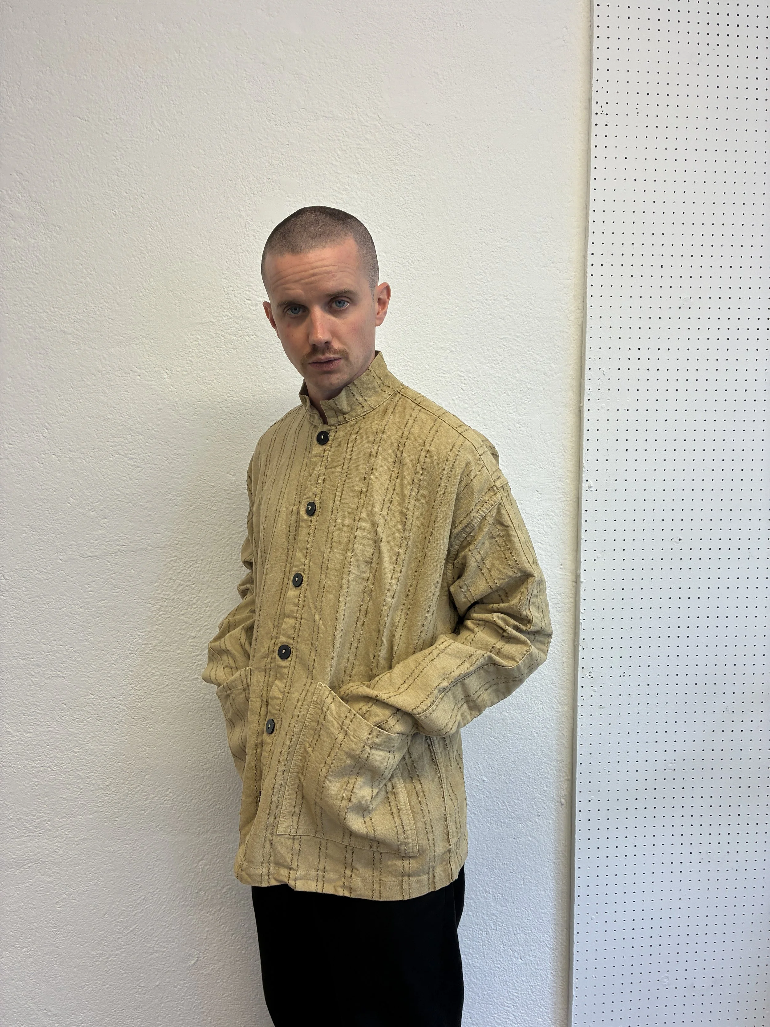 Man wearing  Drab Weld Tender Co Type 485 Isosceles Shirt in front of white wall