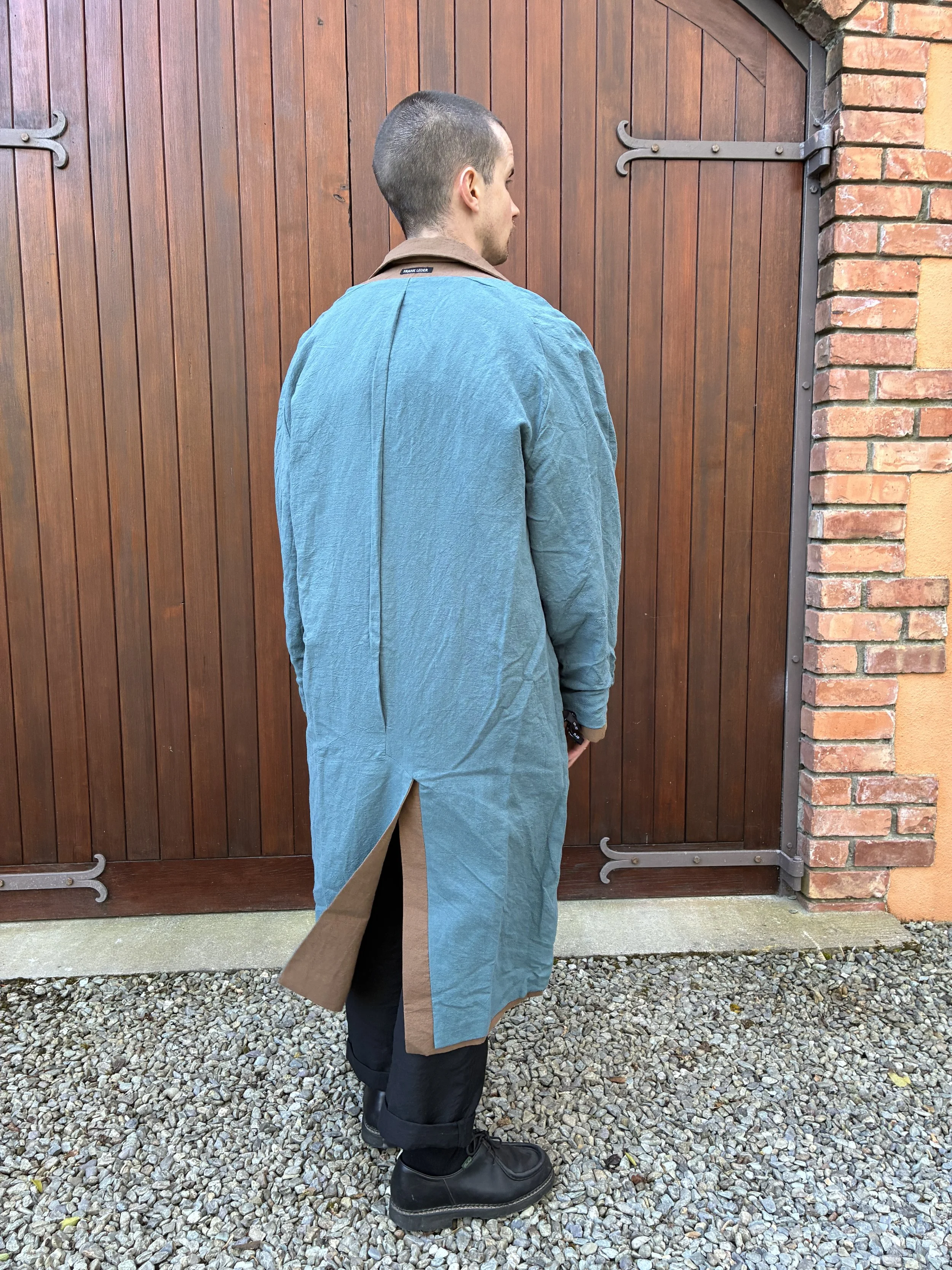 Back of man in front of door wearing Frank Leder Reversible Coat Teal