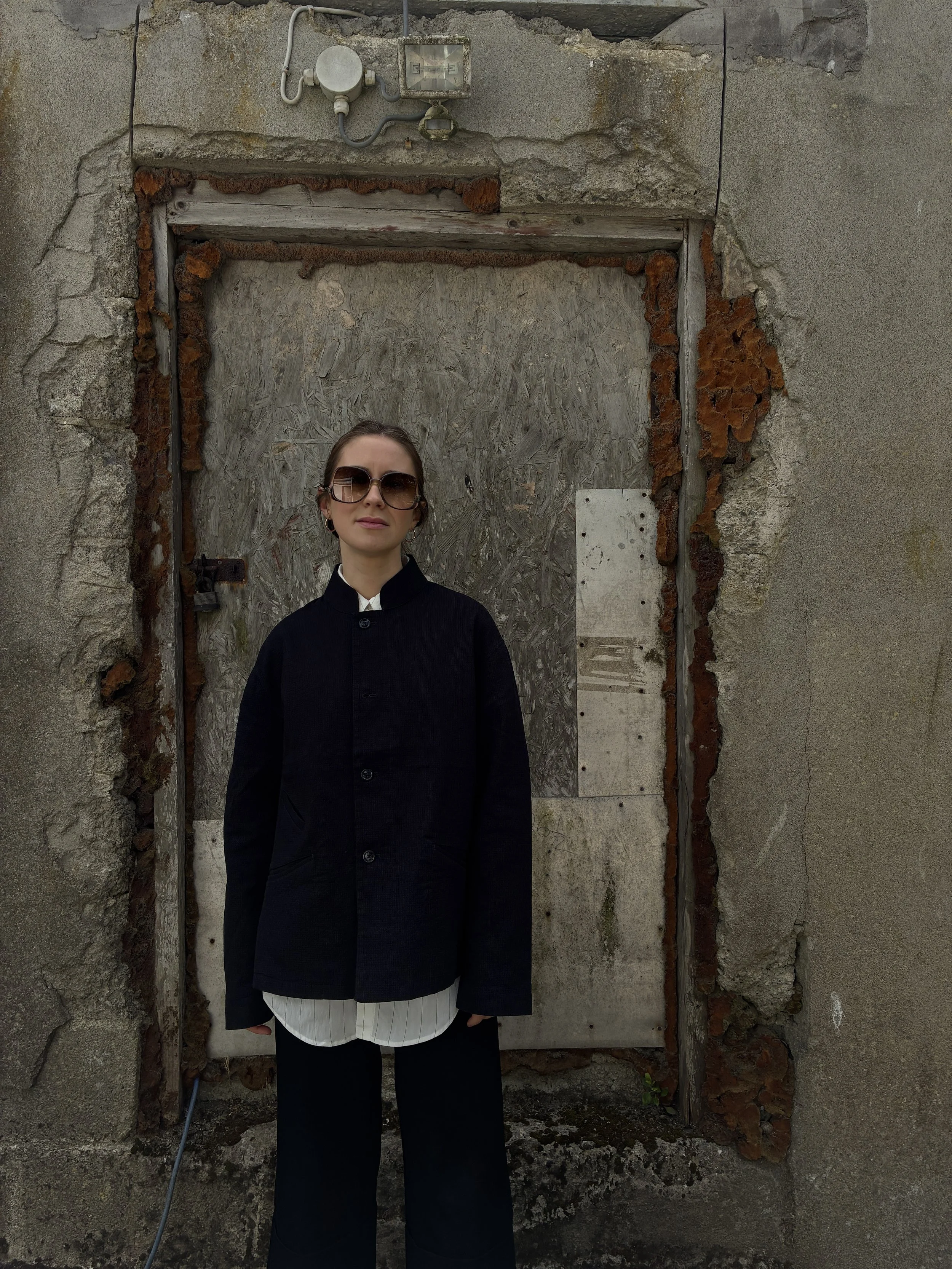 Woman in front of wall wearing Charcoal 1st PAT-RN Woman Rei Jacket