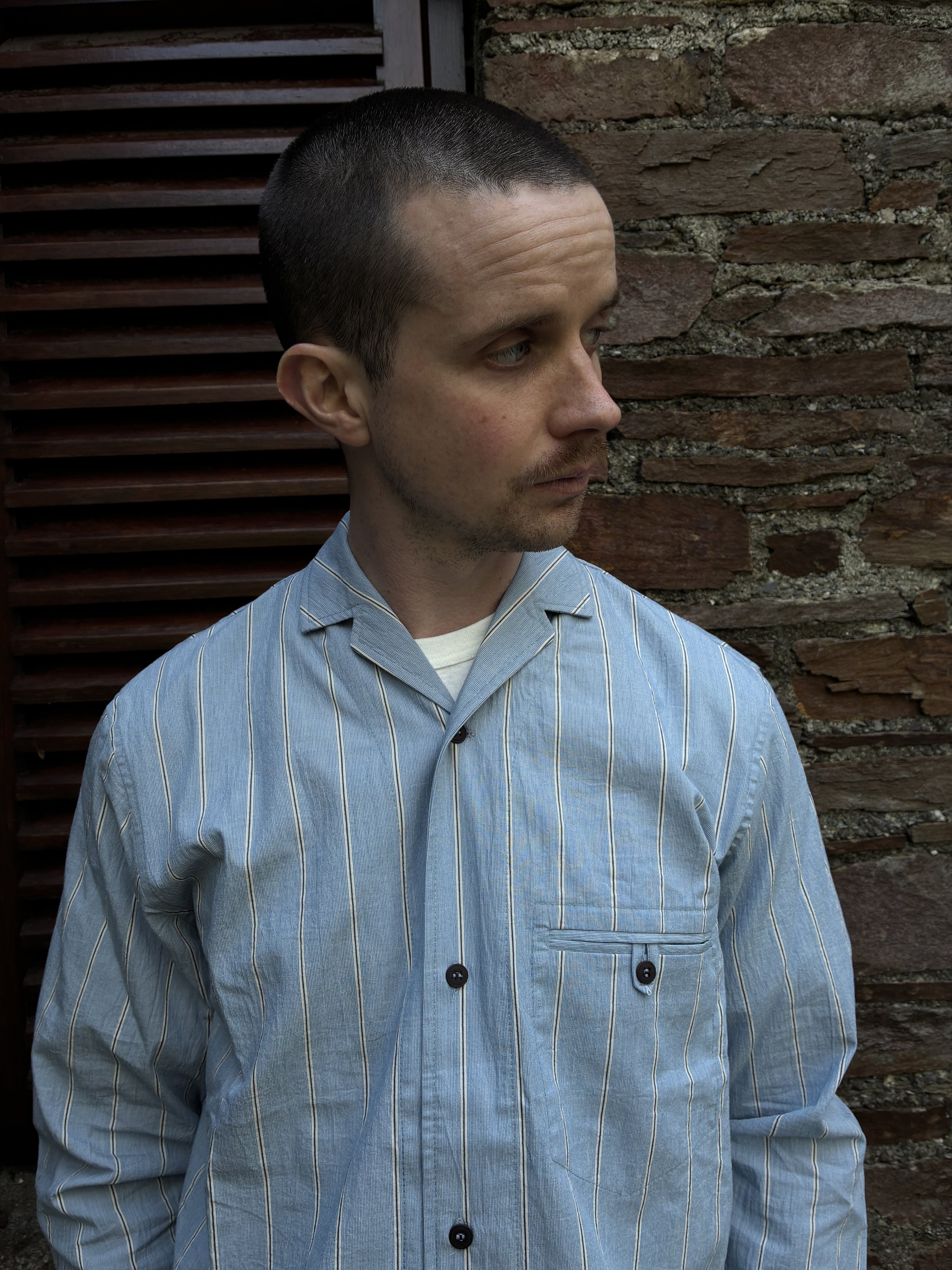 Close up of Man wearing Frank Leder Japanese Cotton Blue Striped Shirt in front of wall