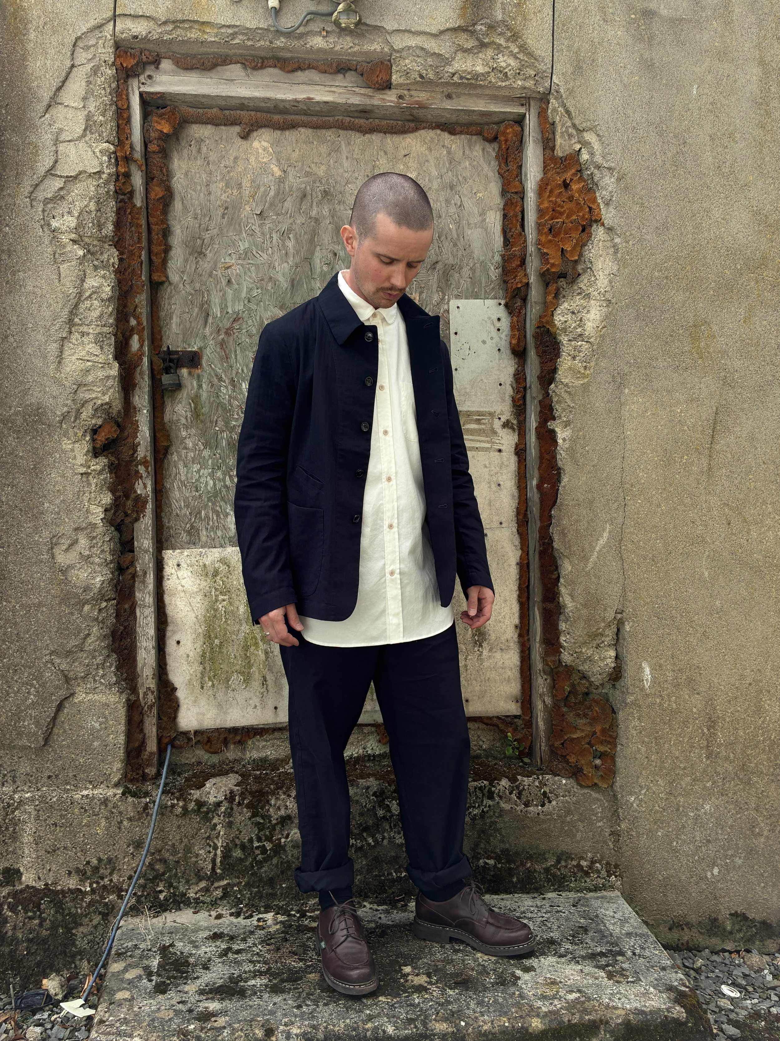 Man in front of wall wearing Navy 1st PAT-RN Notion Jacket