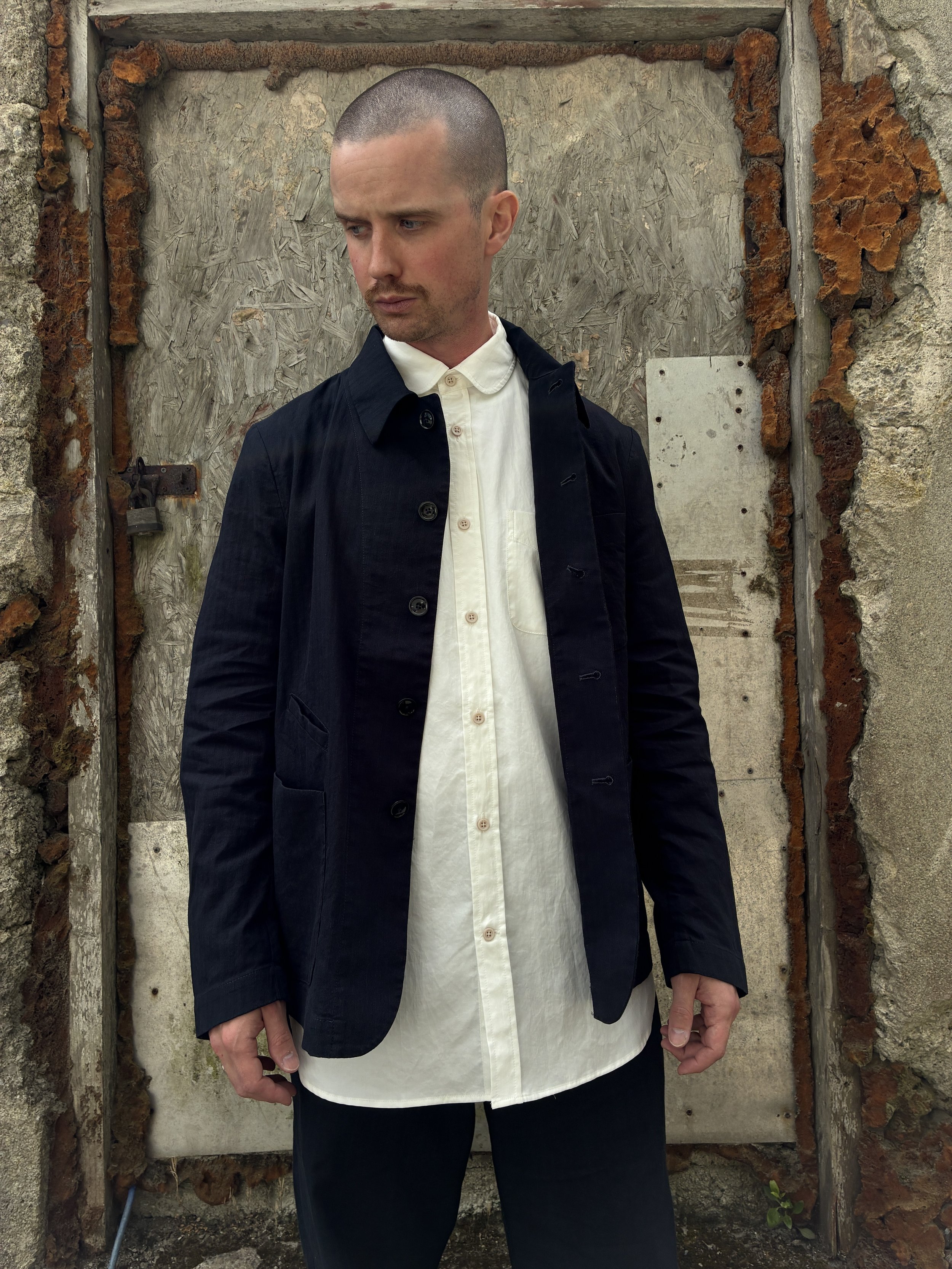 Man in front of wall wearing Navy 1st PAT-RN Notion Jacket