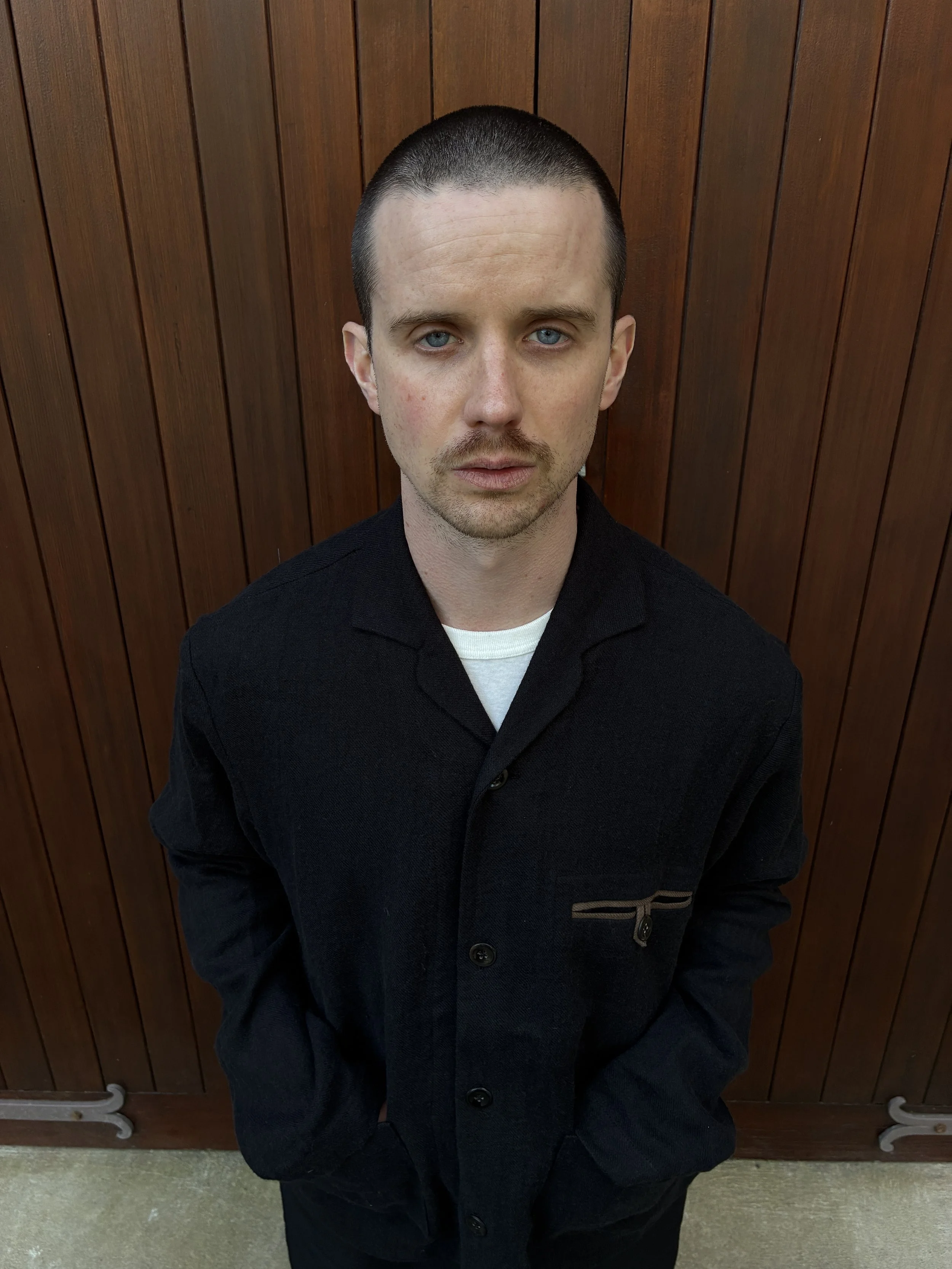 Close up of Man in front of door wearing Frank Leder Black Wool Shirt Jacket