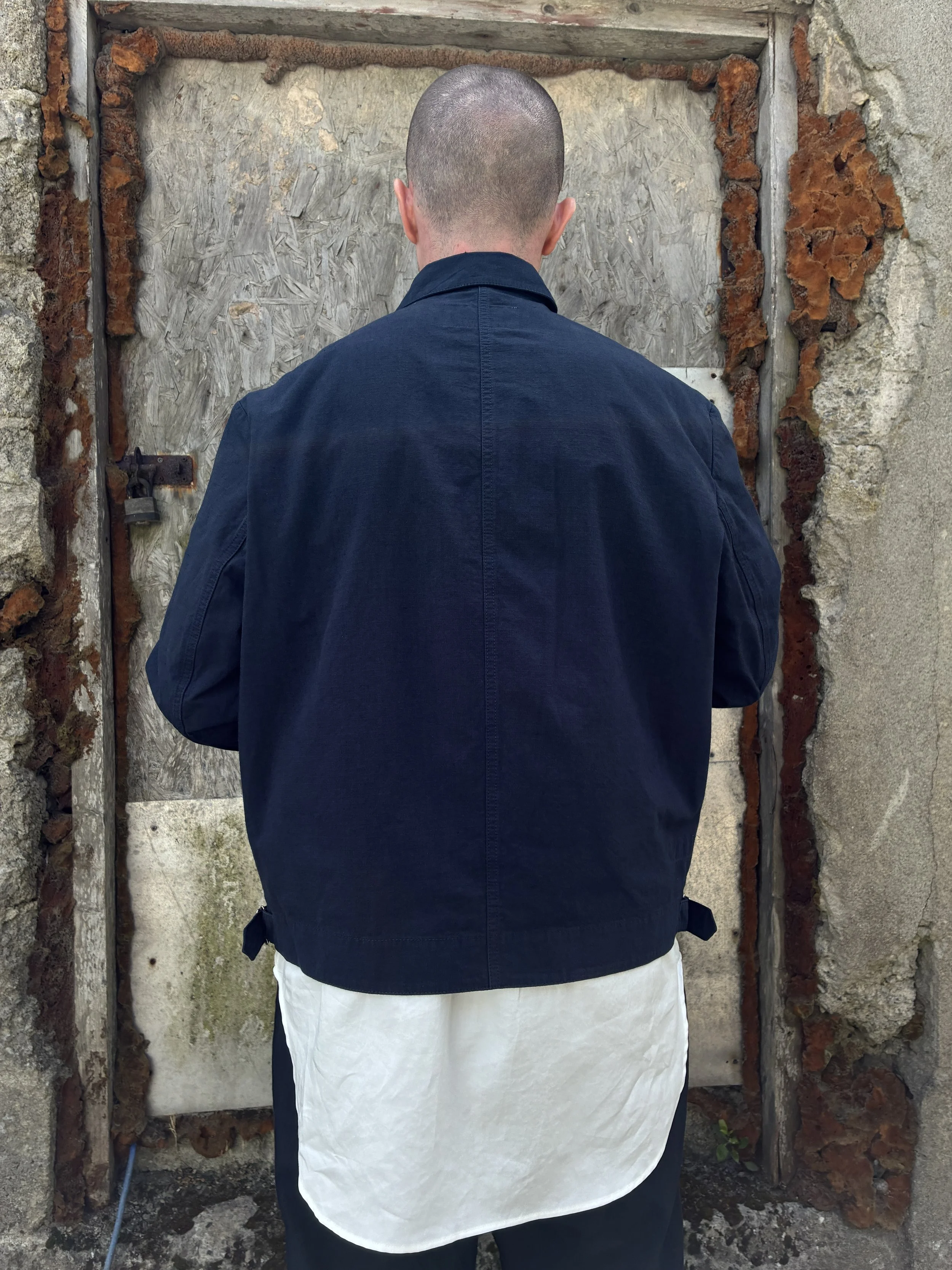 Back of Man in front of wall wearing 1st PAT-RN Navy Camden Jacket