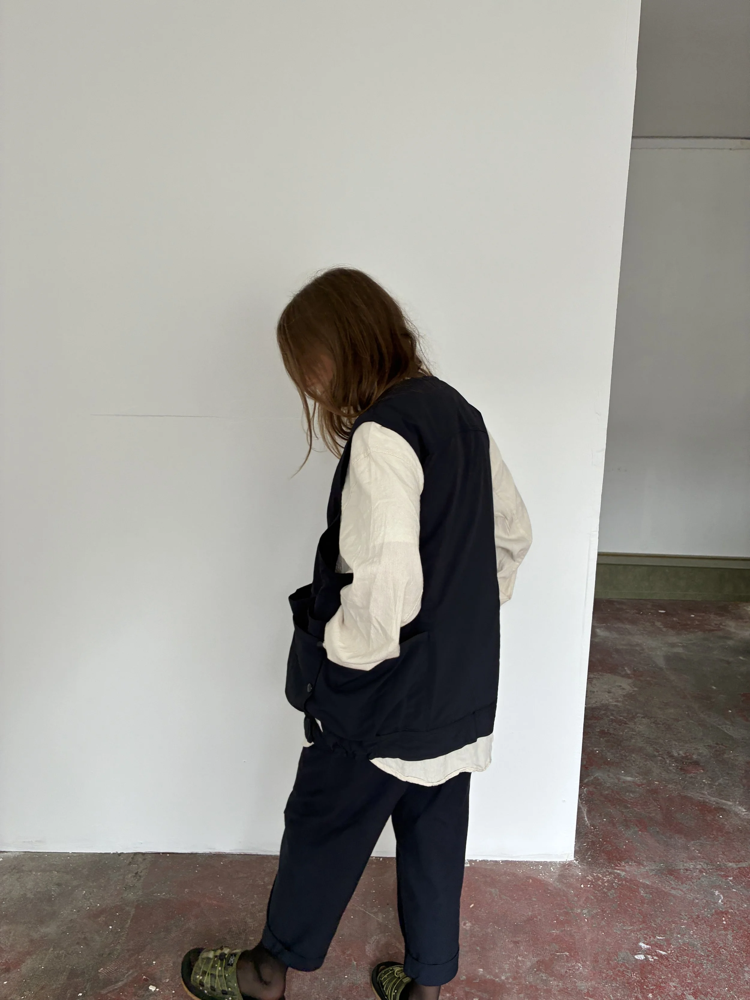 Side of Woman wearing Navy Sassafras Overgrown Hiker Vest inside room