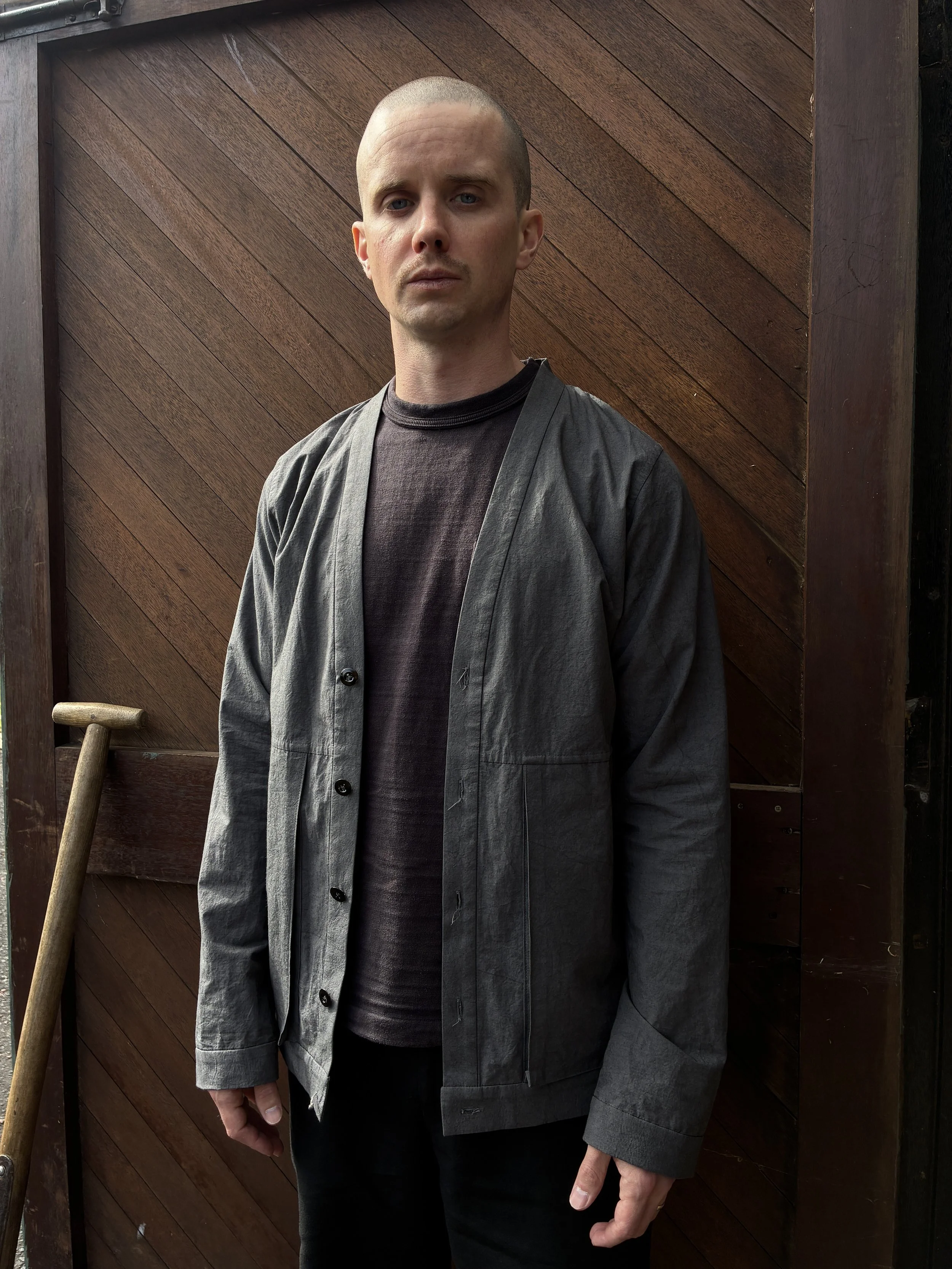 Man in front of wooden door wearing Frank Leder Grey Japanese Cotton Cardigan