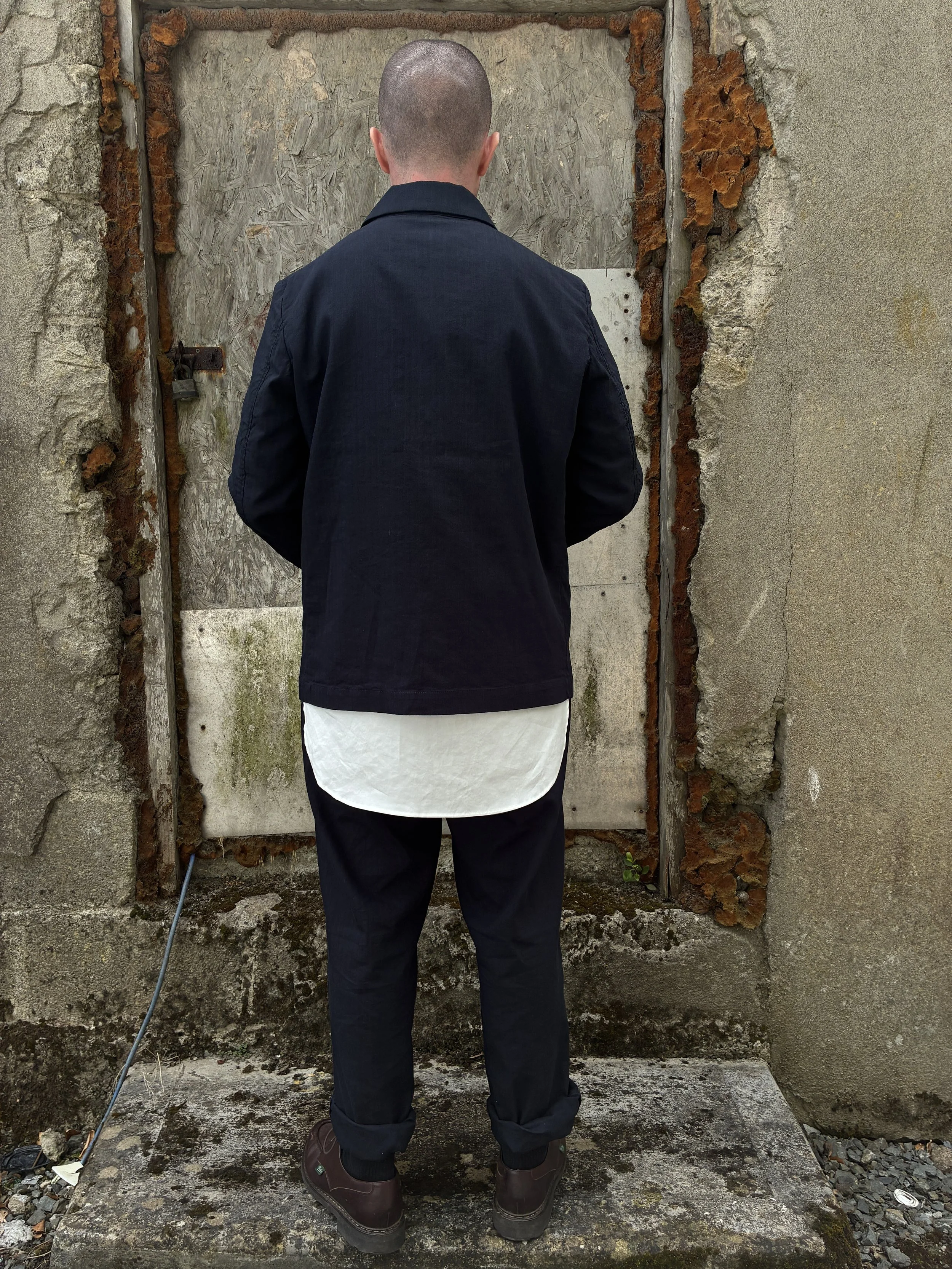 Back of Man in front of wall wearing Navy 1st PAT-RN Notion Jacket