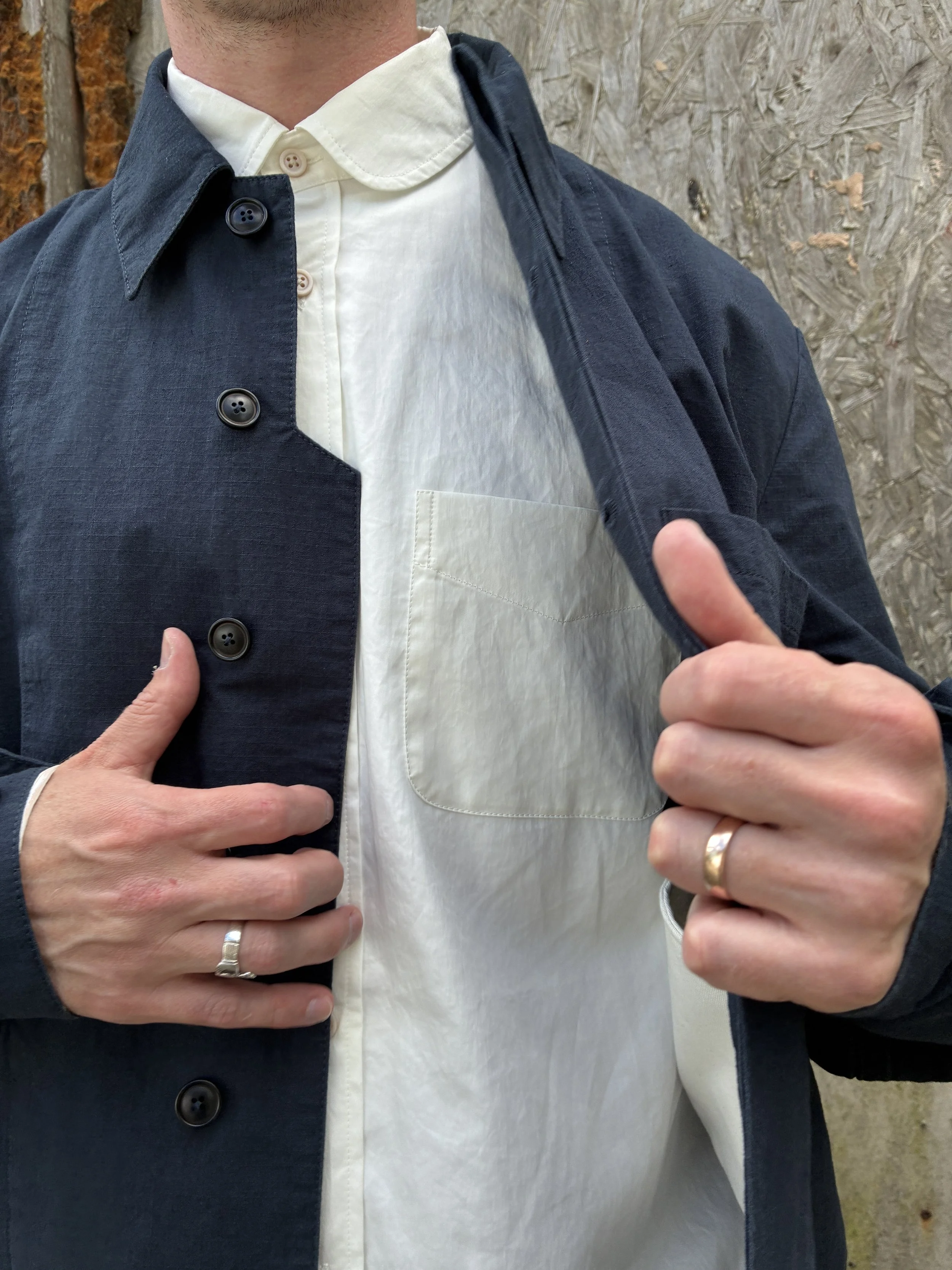 Closeup of Man in front of wall wearing 1st PAT-RN Navy Camden Jacket