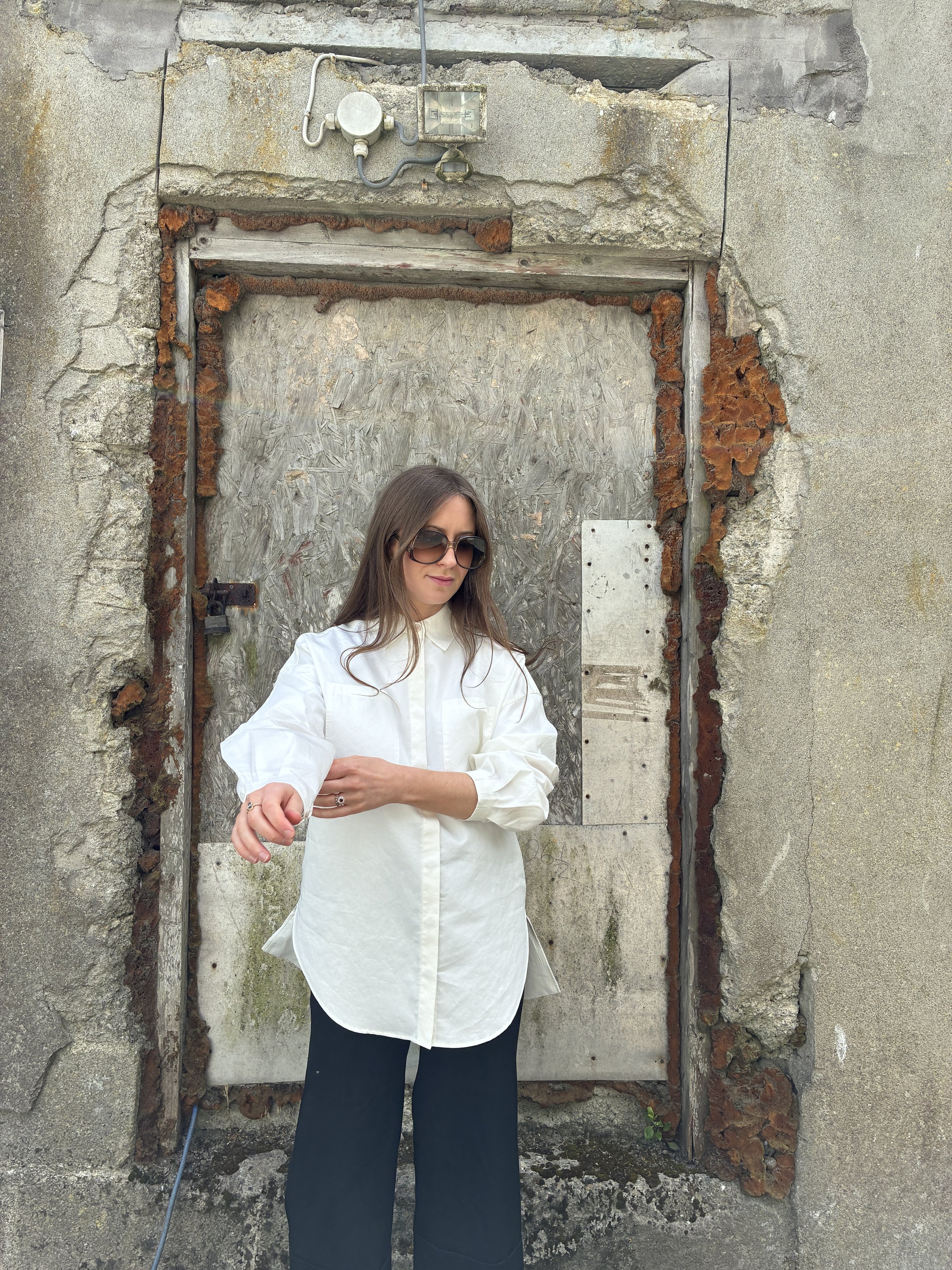 Woman in front of wall wearing White 1st PAT-RN Woman Modula Shirt pulling up sleeves