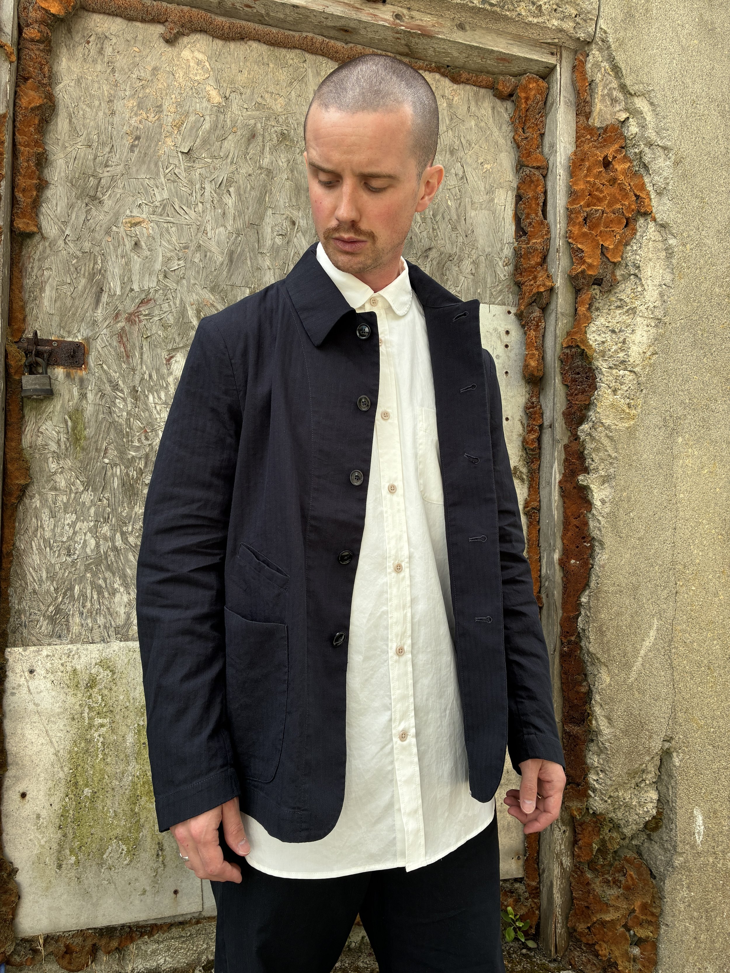 Man in front of wall wearing White 1st PAT-RN Boston Shirt layered under jacket