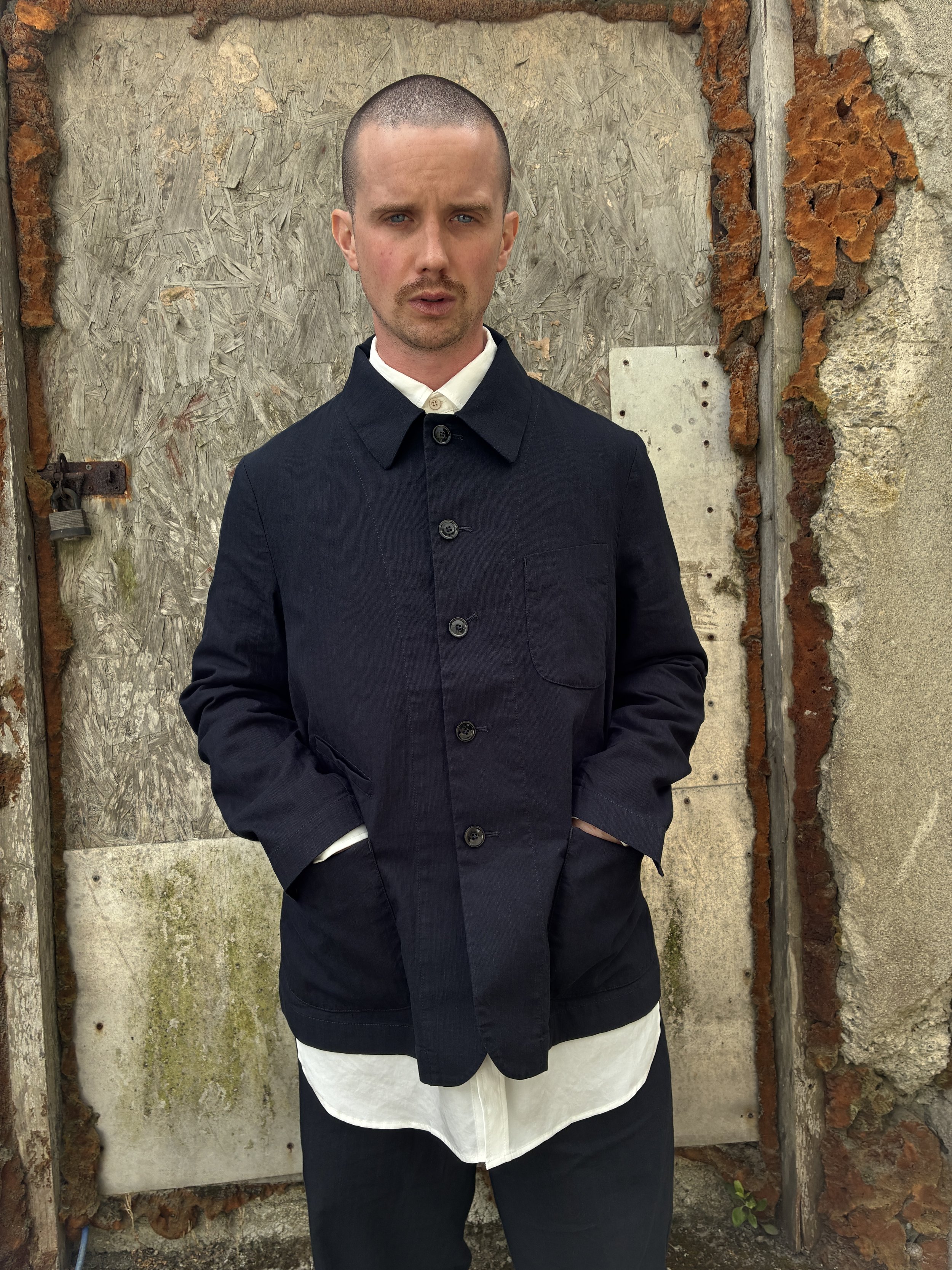 Man in front of wall wearing Navy 1st PAT-RN Notion Jacket