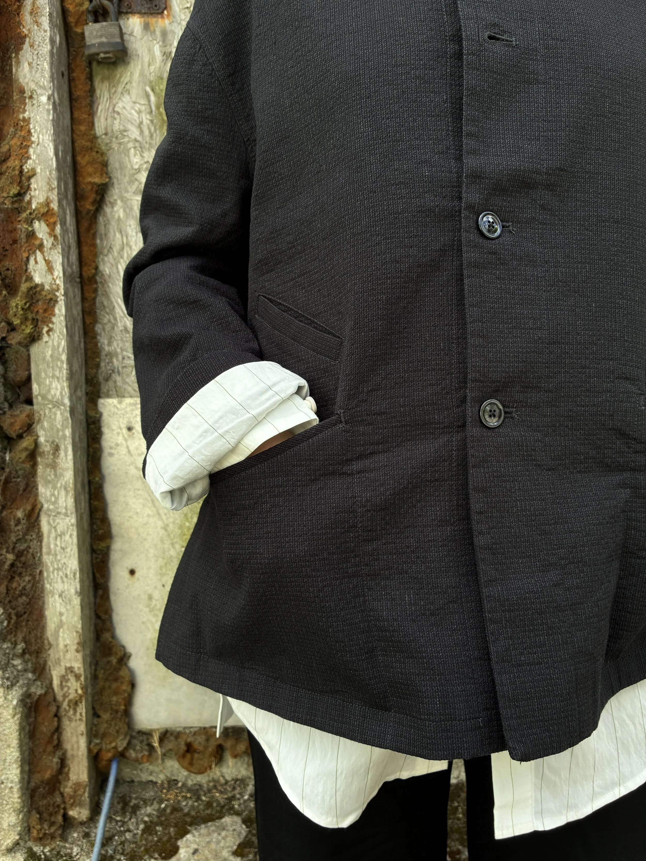 Closeup of Woman in front of wall wearing Charcoal 1st PAT-RN Woman Rei Jacket with hands in pockets
