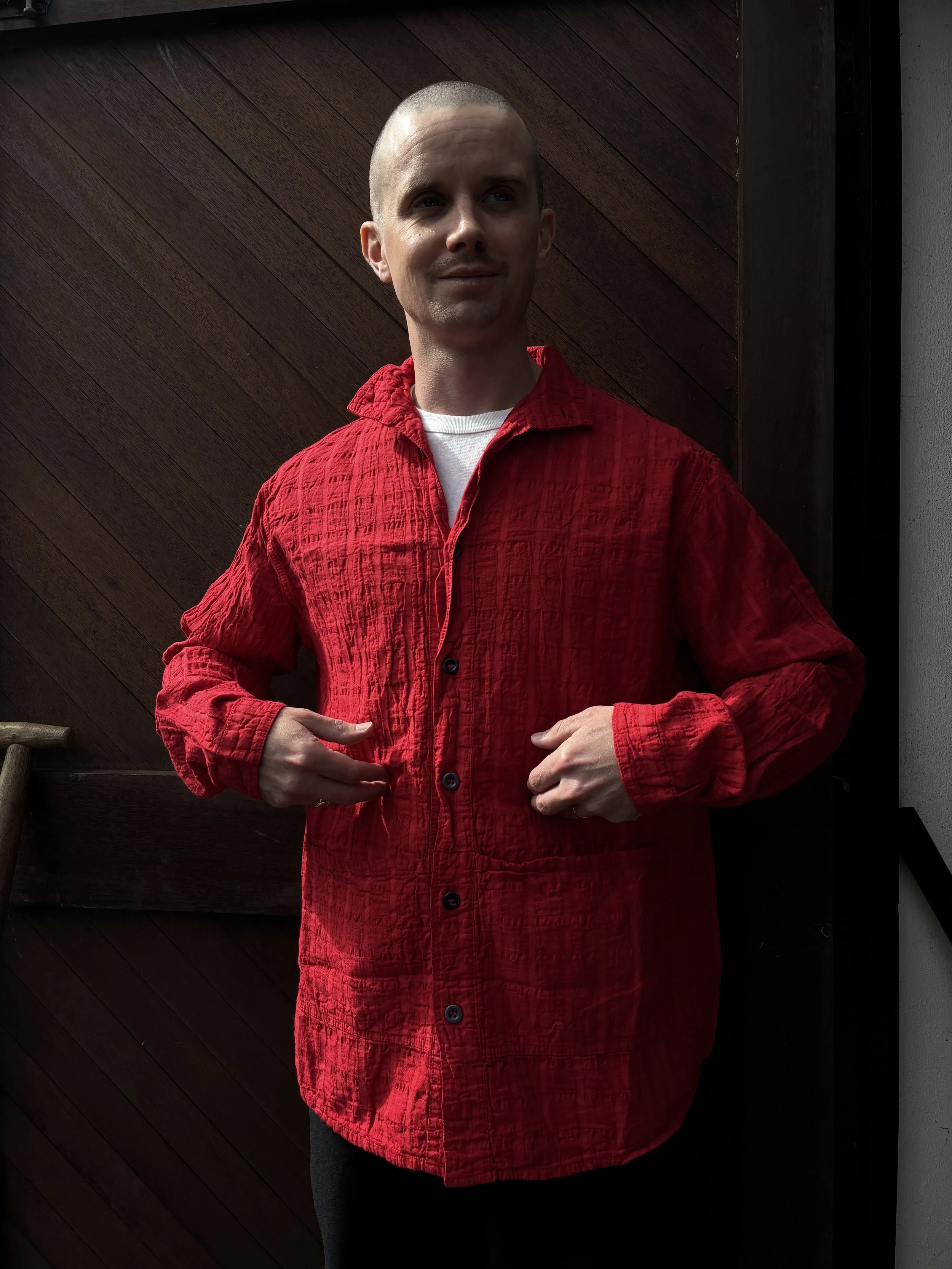 Man in front of wooden door putting hands in pockets of Red Tender Co. 468 Flipped Collar Shirt
