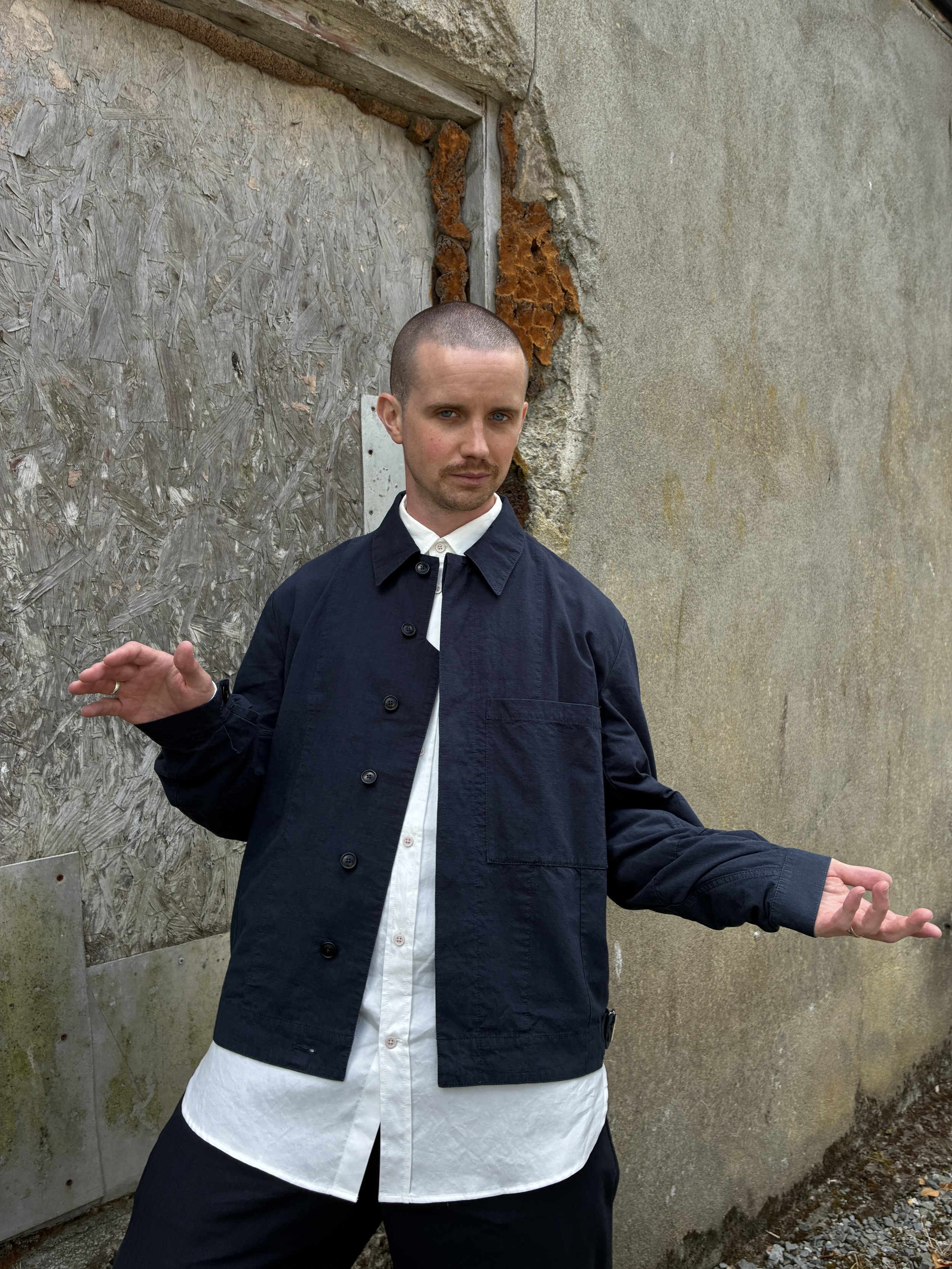 Man posing in front of wall wearing 1st PAT-RN Navy Camden Jacket