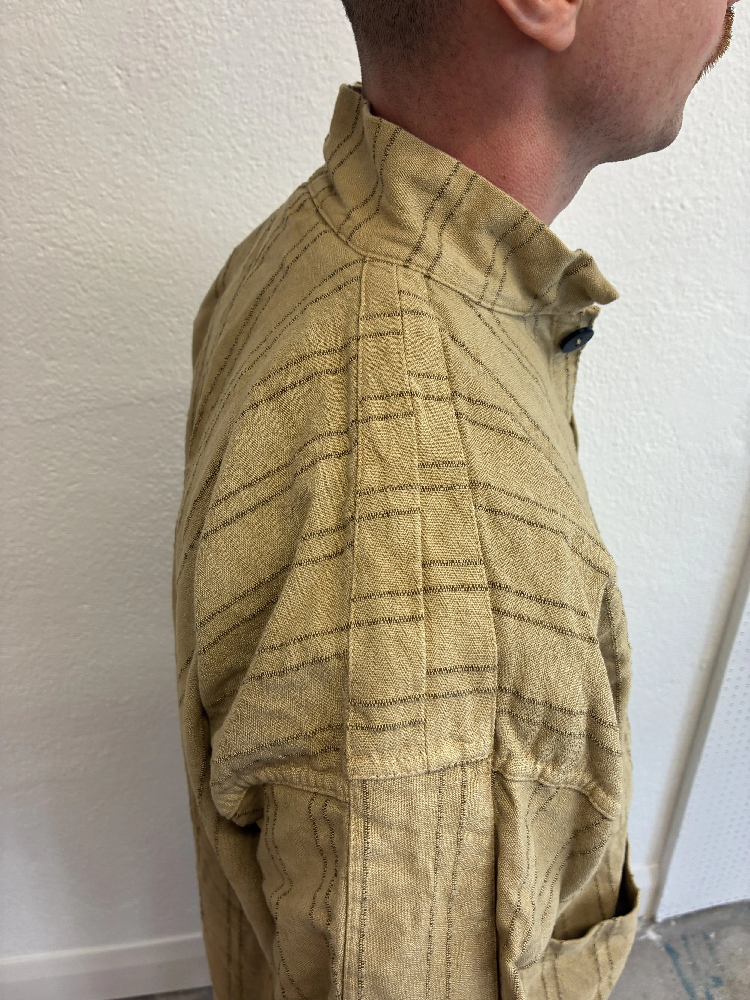 Closeup of shoulder of Drab Weld Tender Co Type 485 Isosceles Shirt in front of white wall