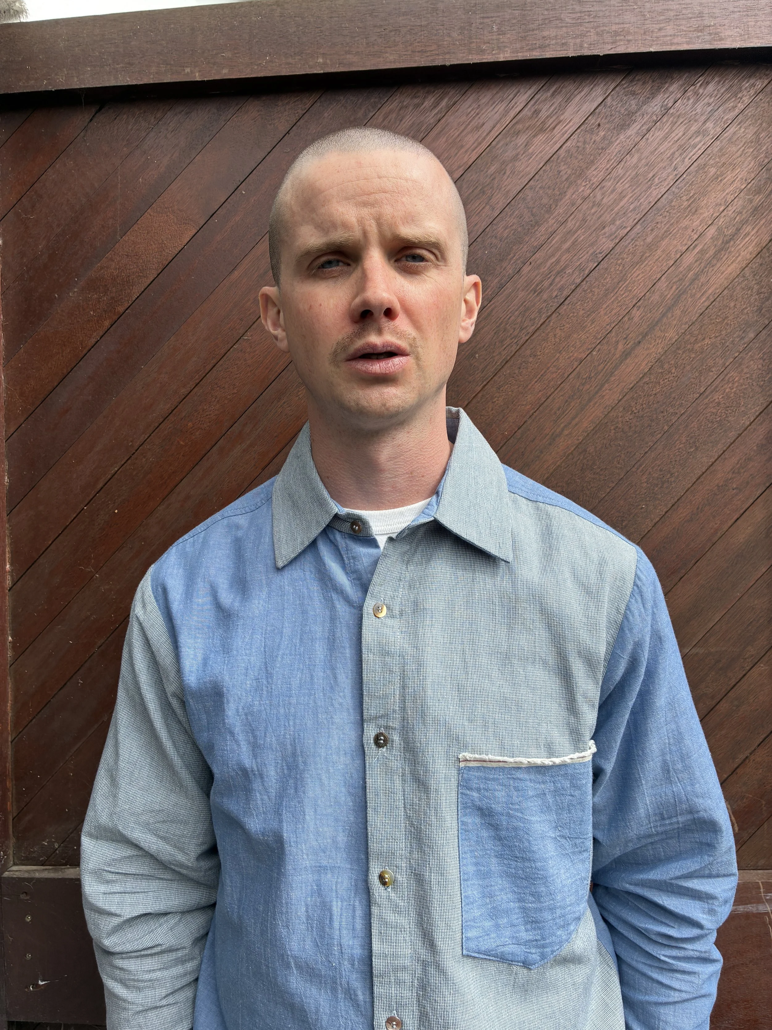 Closeup of man in front of door wearing Frank Leder Blue Patchwork Vintage Fabric Edition Shirt