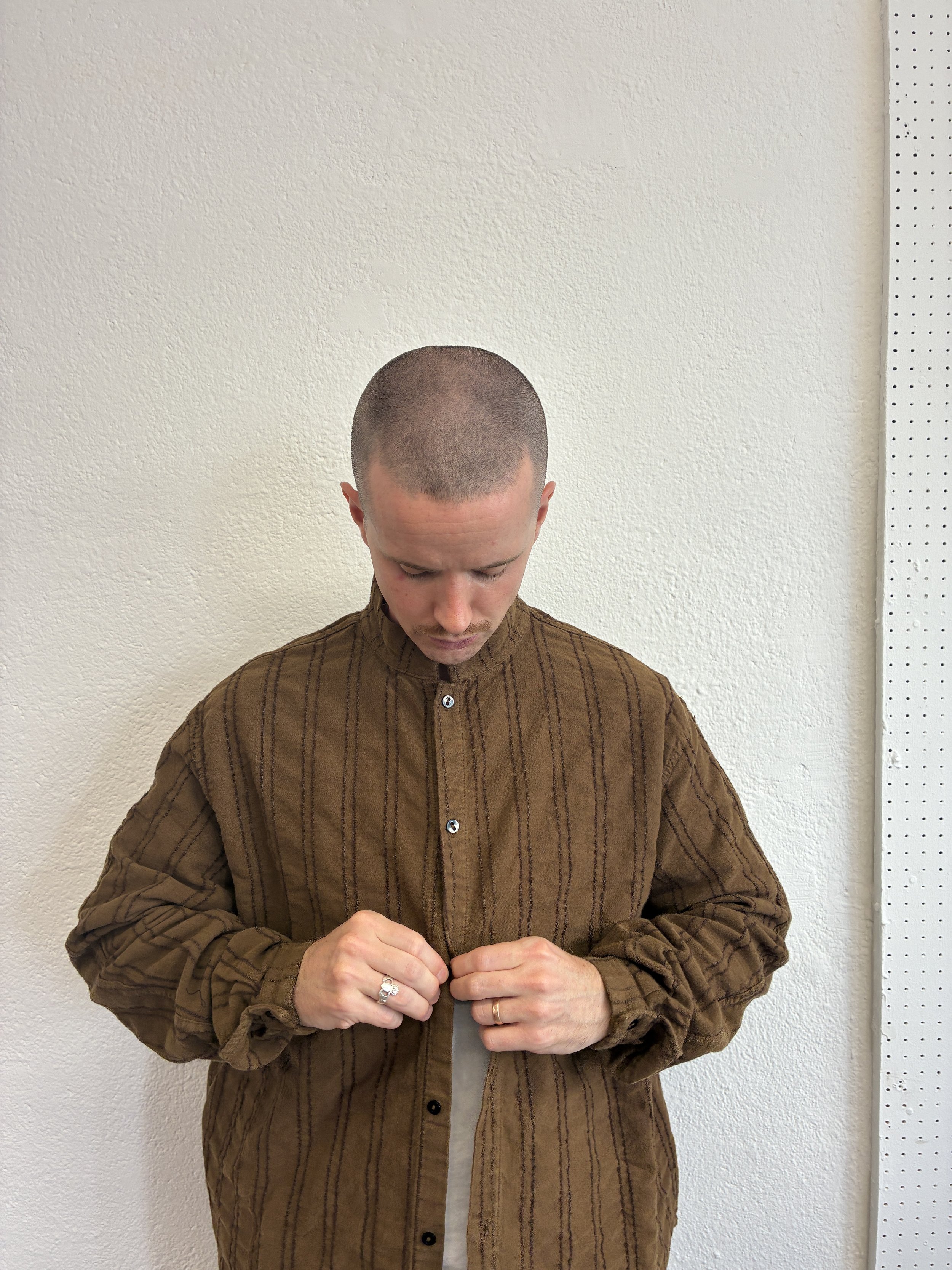 Man buttoning up Brown Tender Co Type 486 Burro Shirt