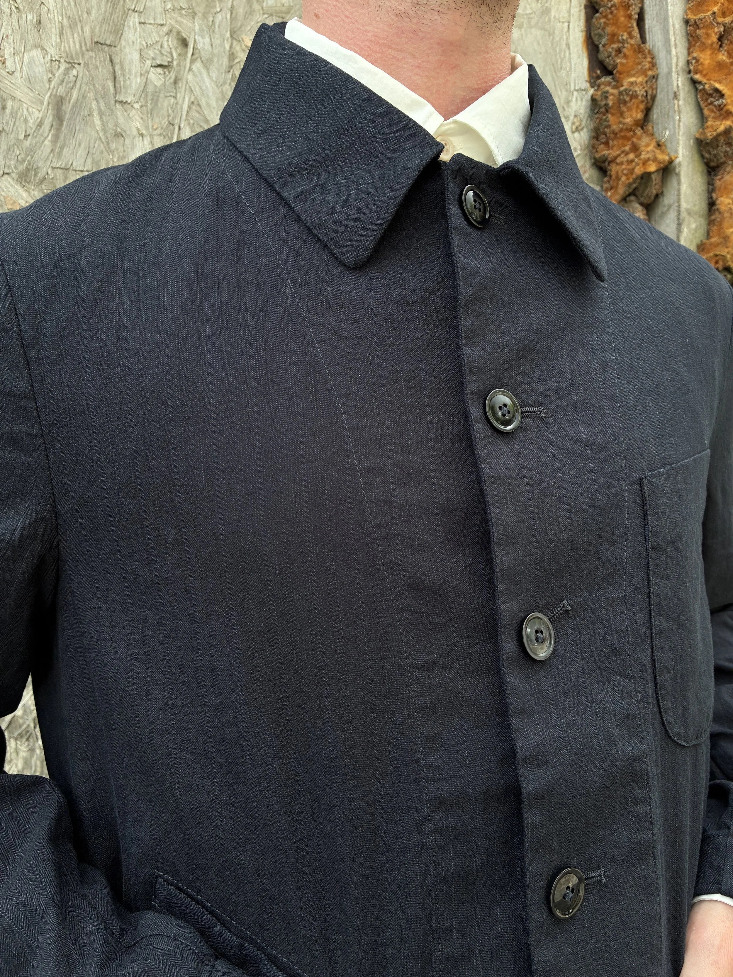 Closeup of collar of Man in front of wall wearing Navy 1st PAT-RN Notion Jacket