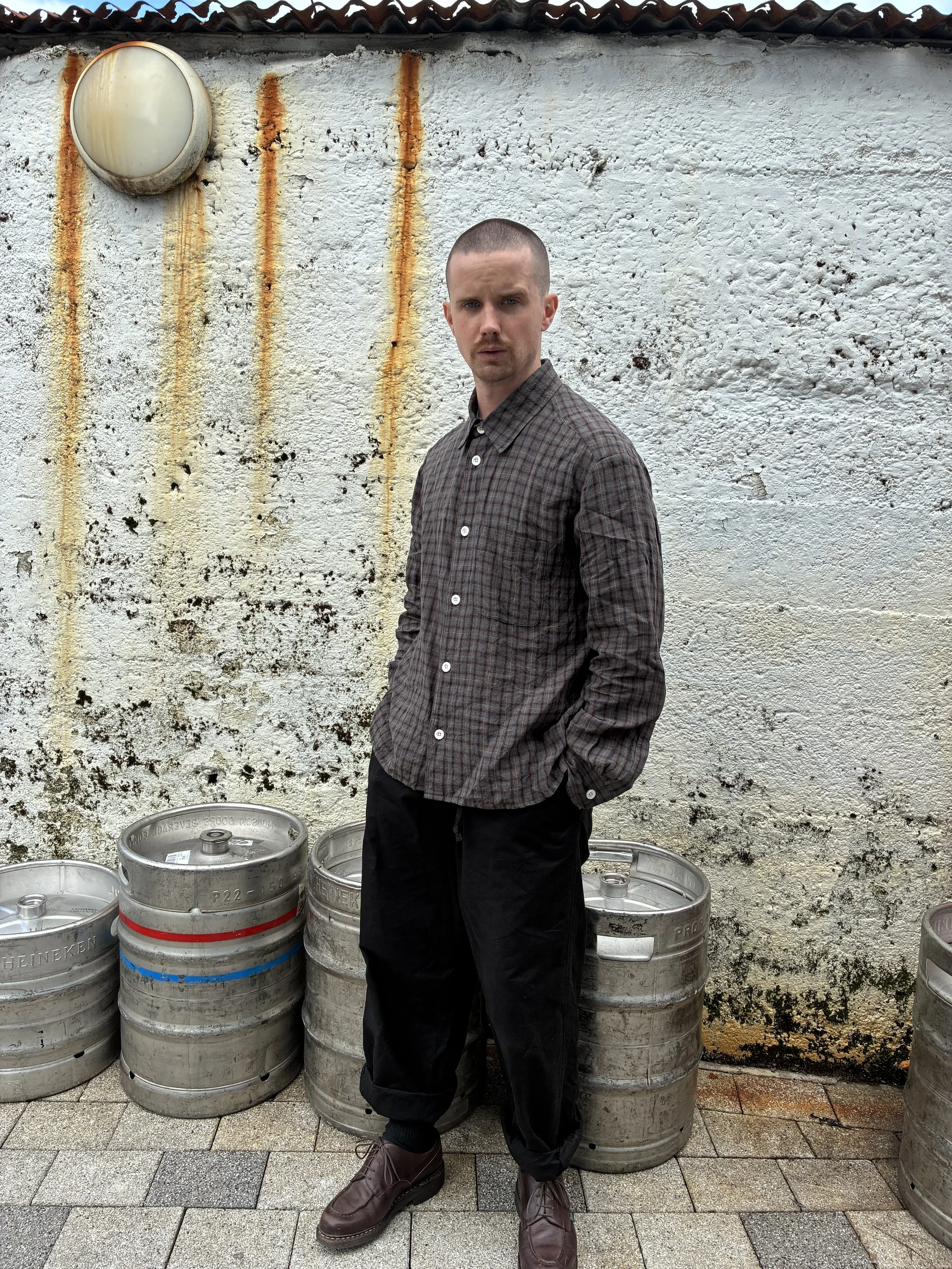 Man wearing Dusk Conkers Relaxed Farmer Shirt beside beer kegs