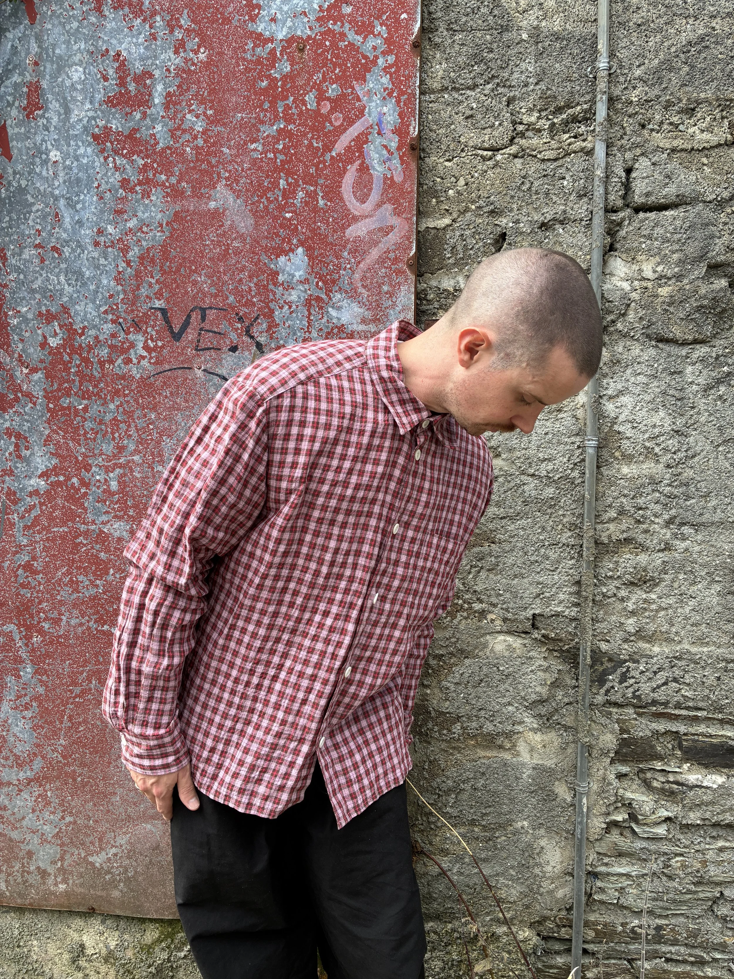 Man wearing Conkers Sunrise Relaxed Farmer Shirt in front of red wall